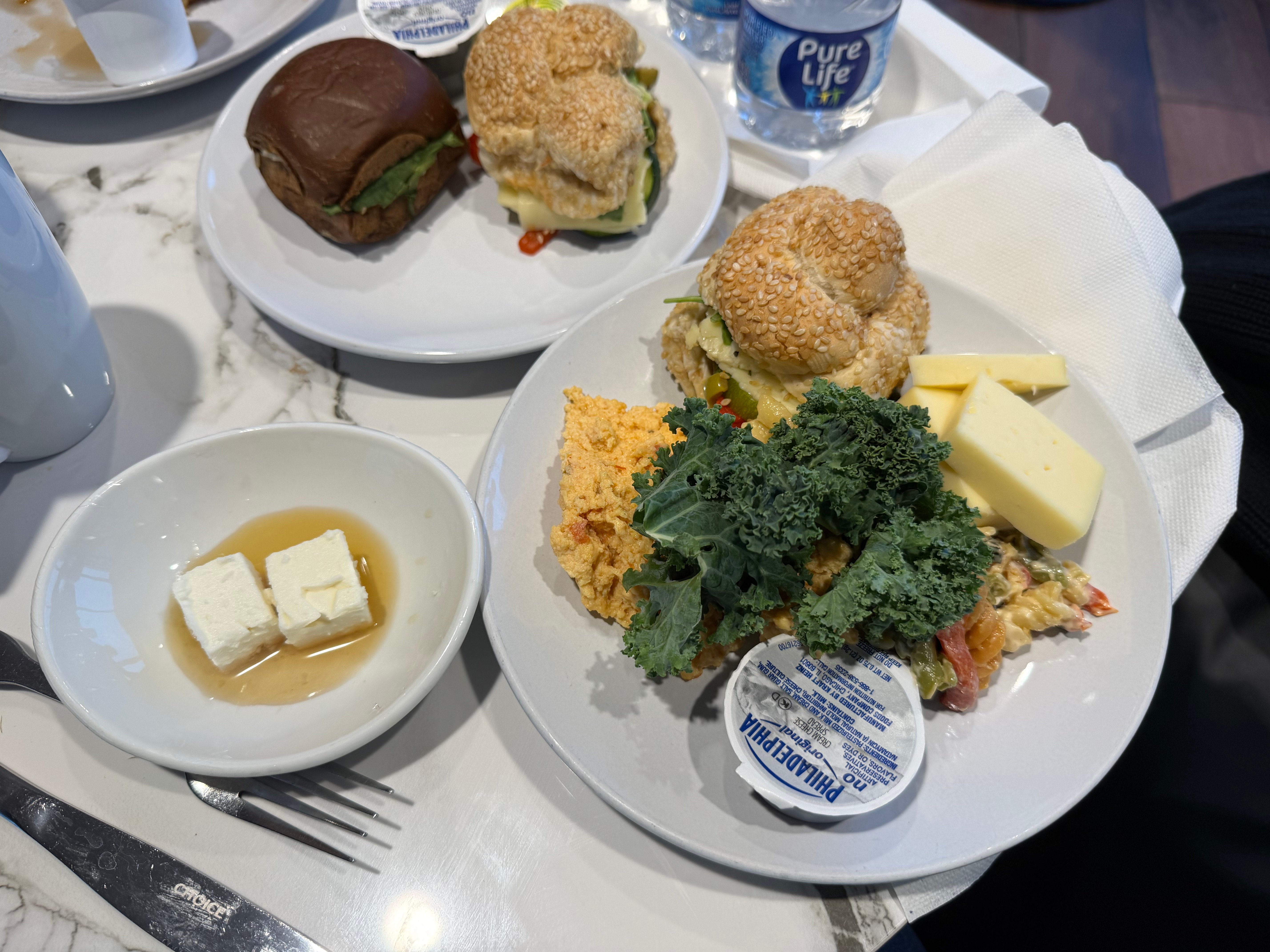 Breakfast plate with eggs, sandwiches, cheese, and salad in the Turkish Airlines Lounge.