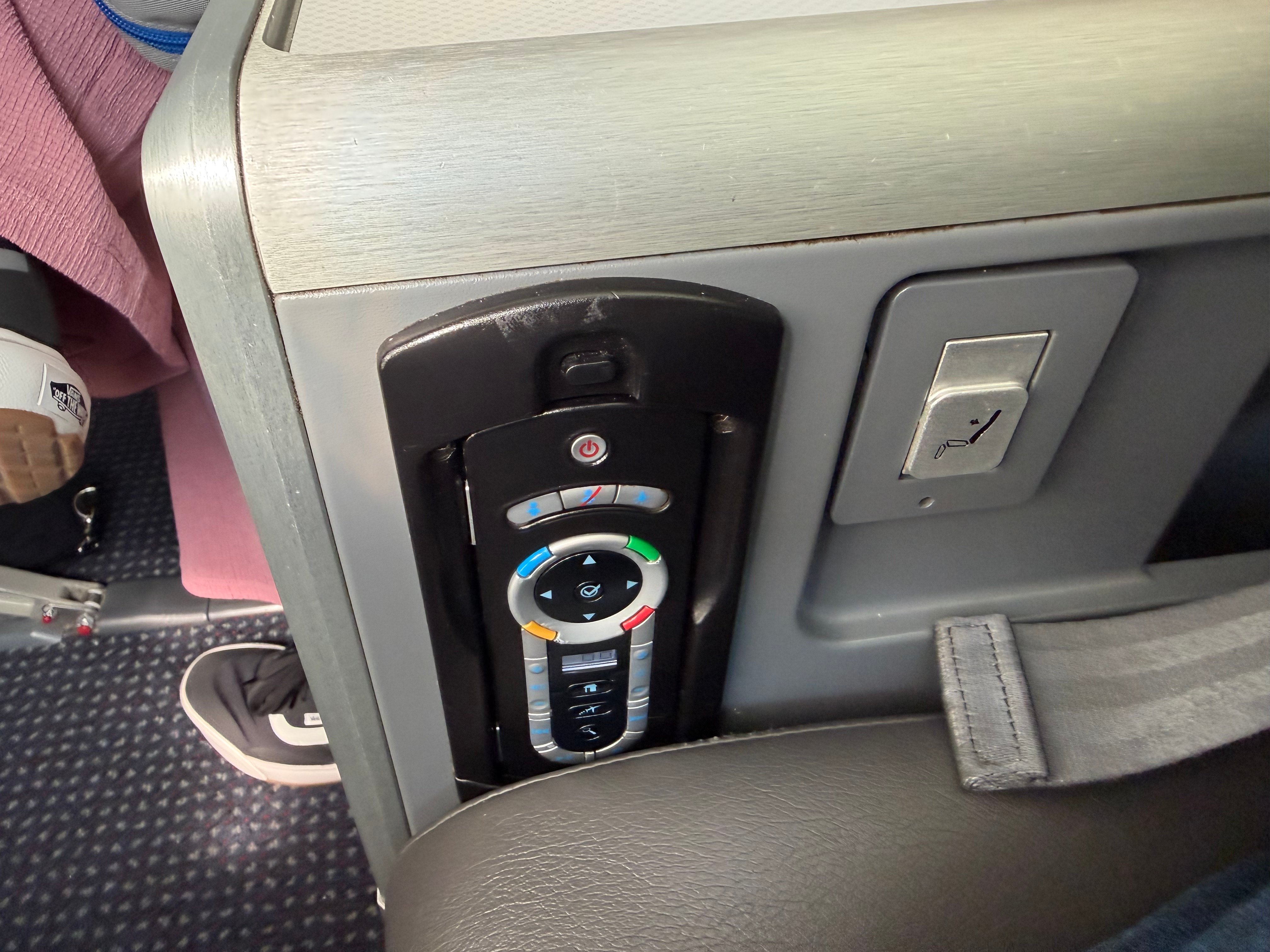 Power connections and controls beside an American 787-8 Main Cabin Extra seat.