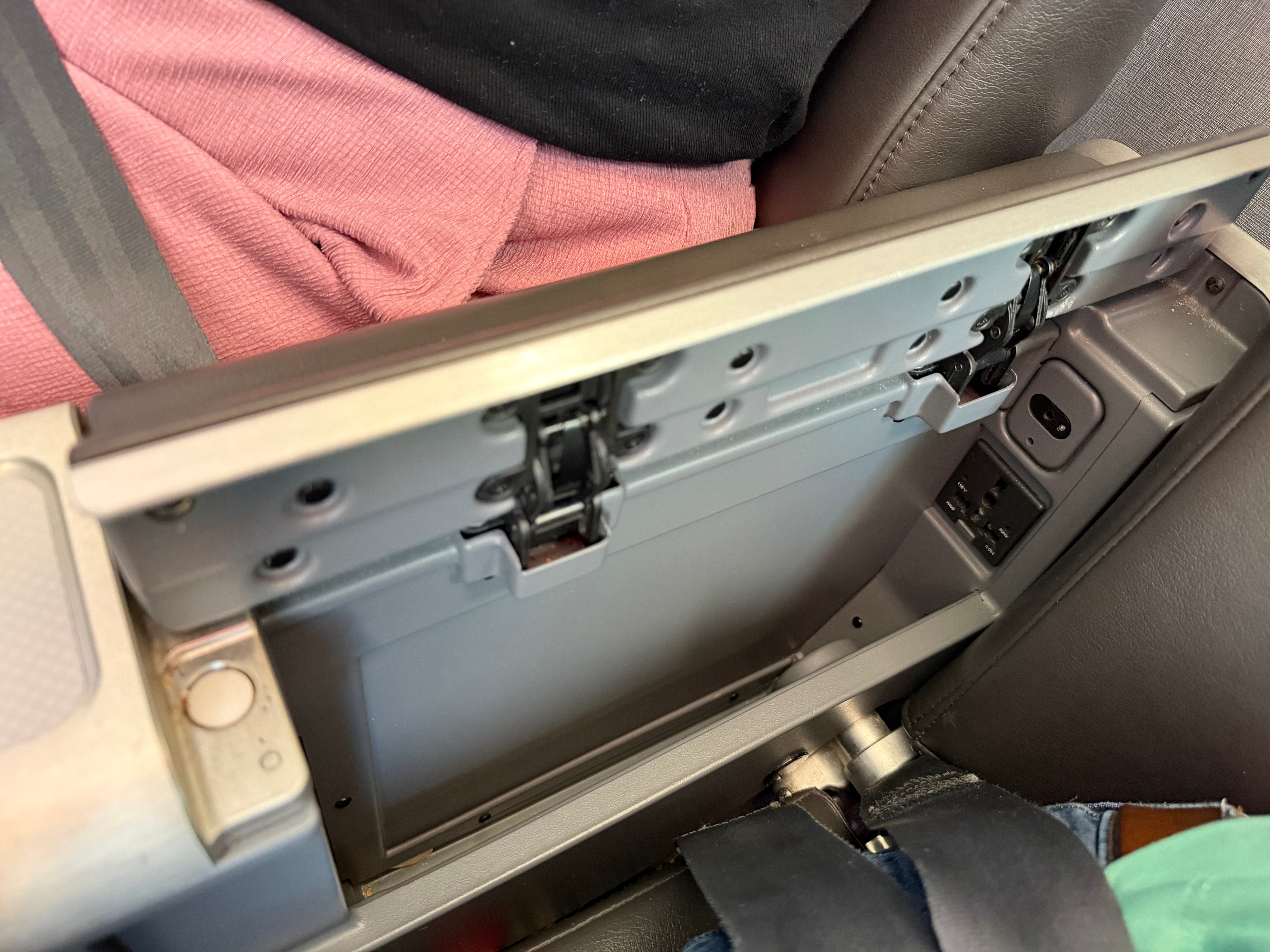 Open center armrest showing the tray table storage in Main Cabin Extra.