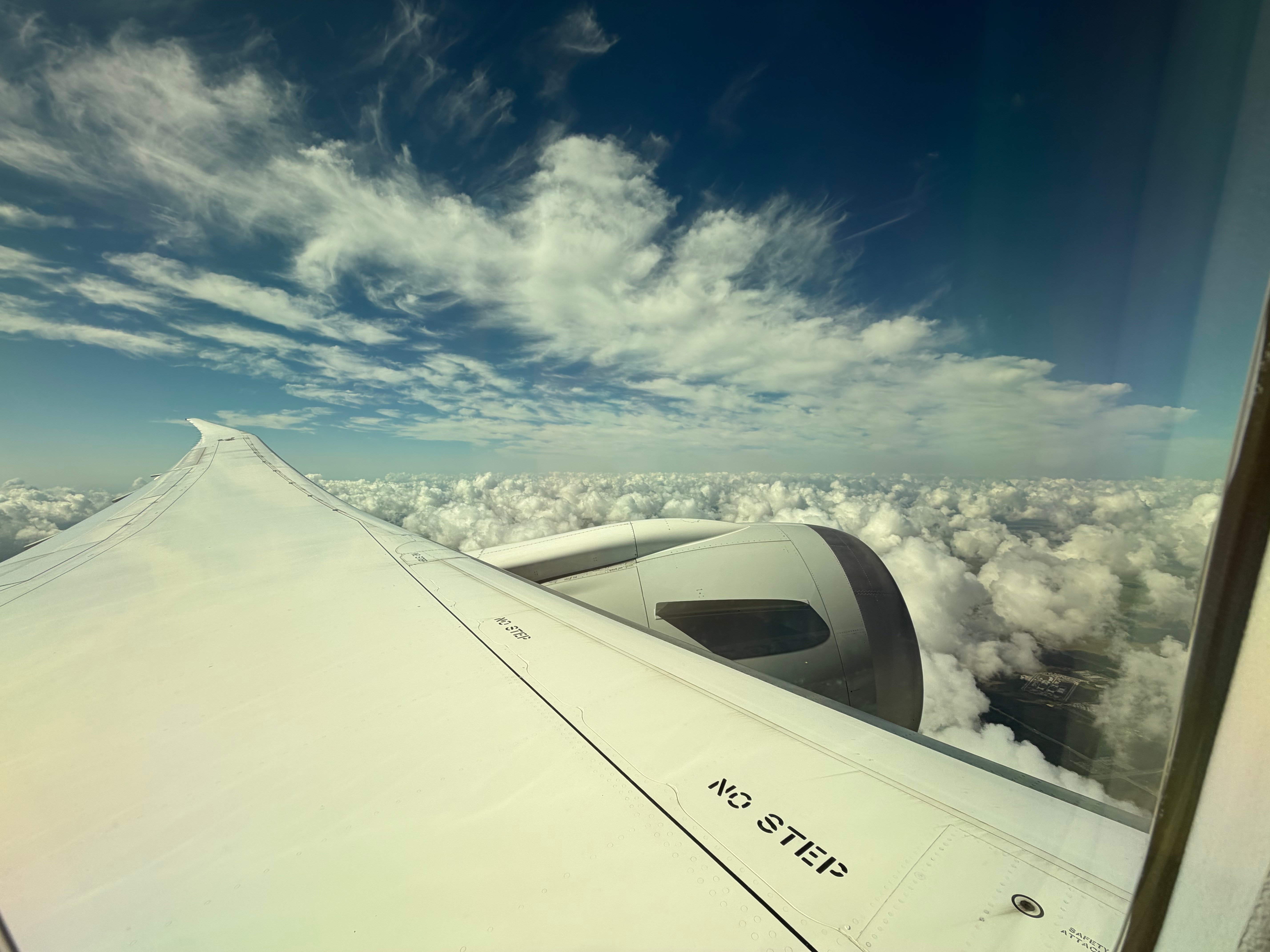 American Airlines Boeing 787-8 wing above the clouds after takeoff.