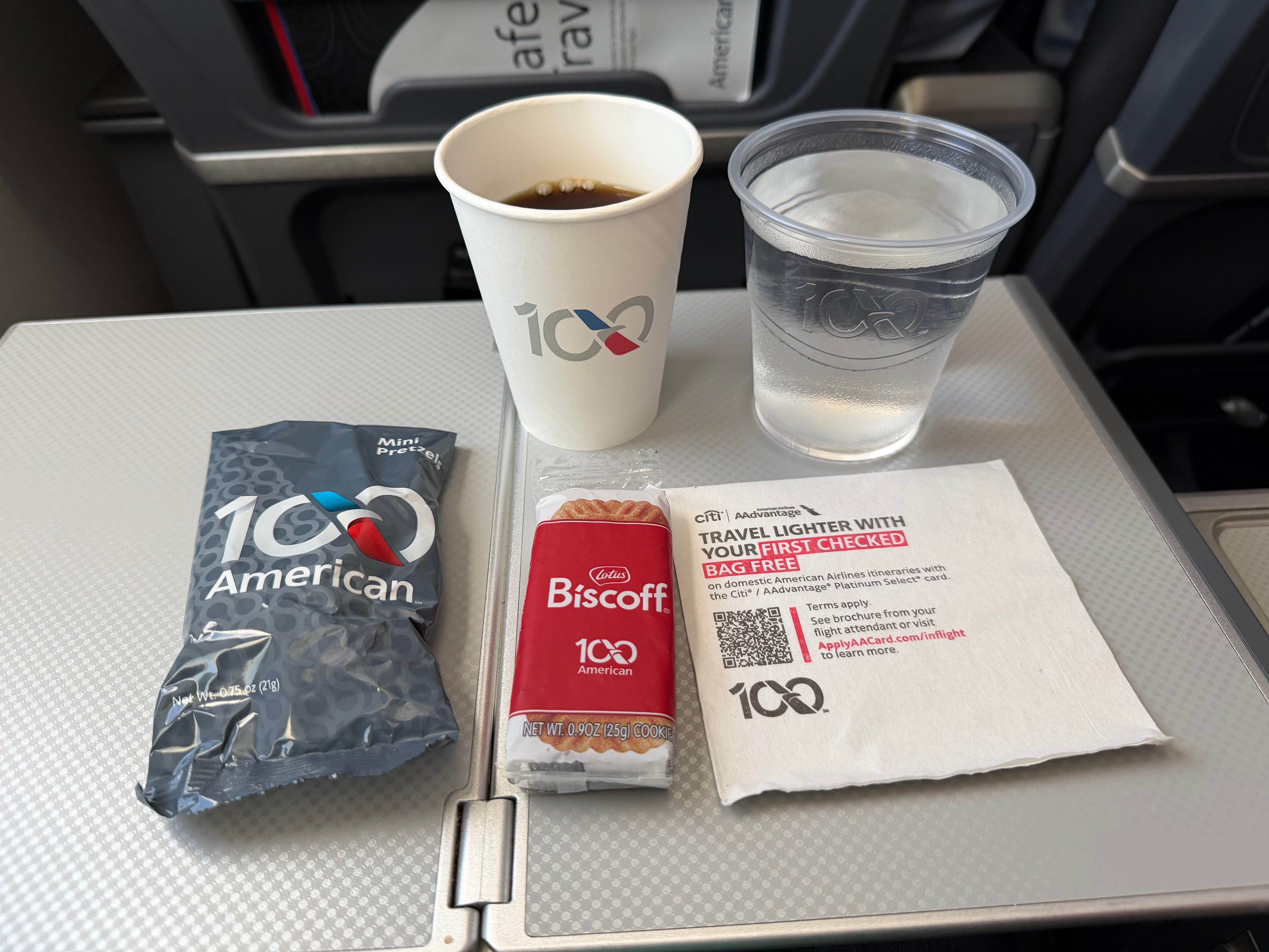 Mini pretzels, Biscoff cookies, coffee, and water served on American Airlines.