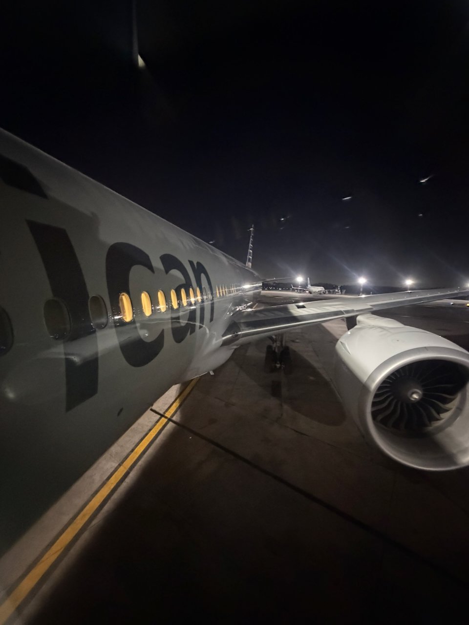 Wing view from the jet bridge window before boarding the American 777.