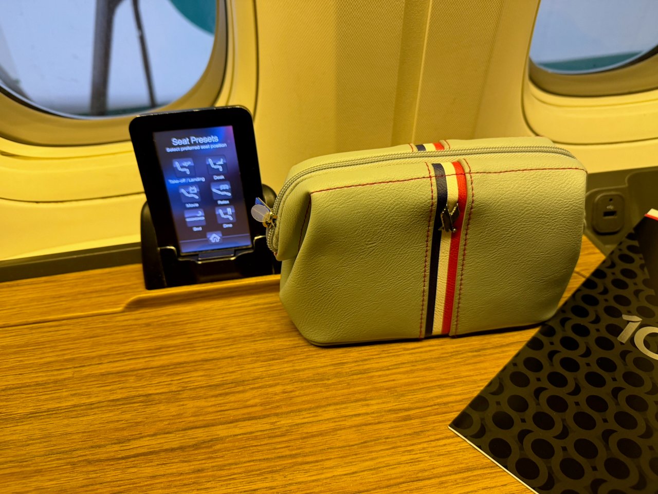 Amenity kit, menu, and seat controls at the American Flagship First seat.