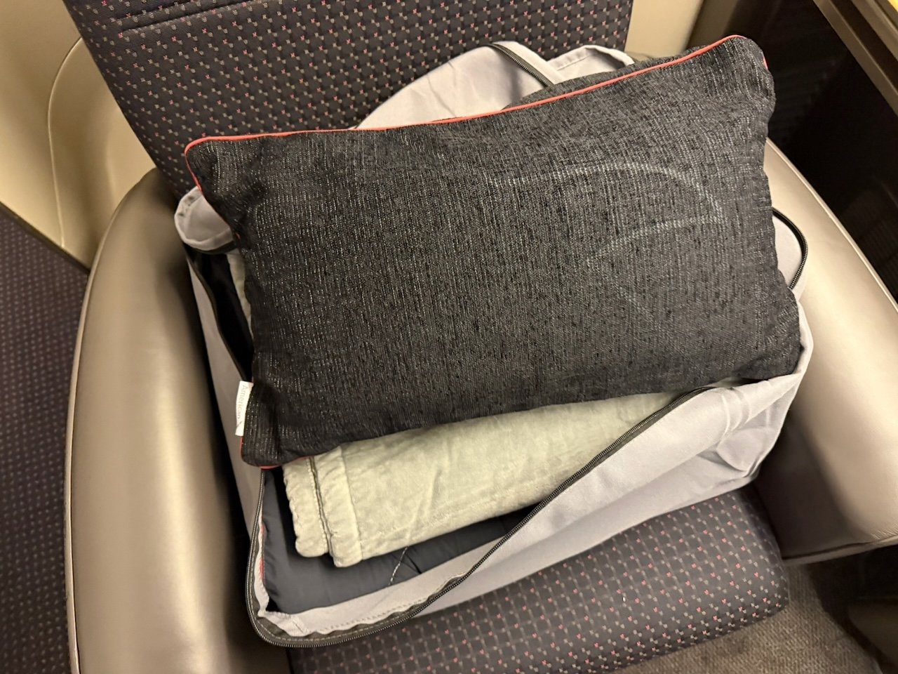 Pillow and blanket provided in American Flagship First.