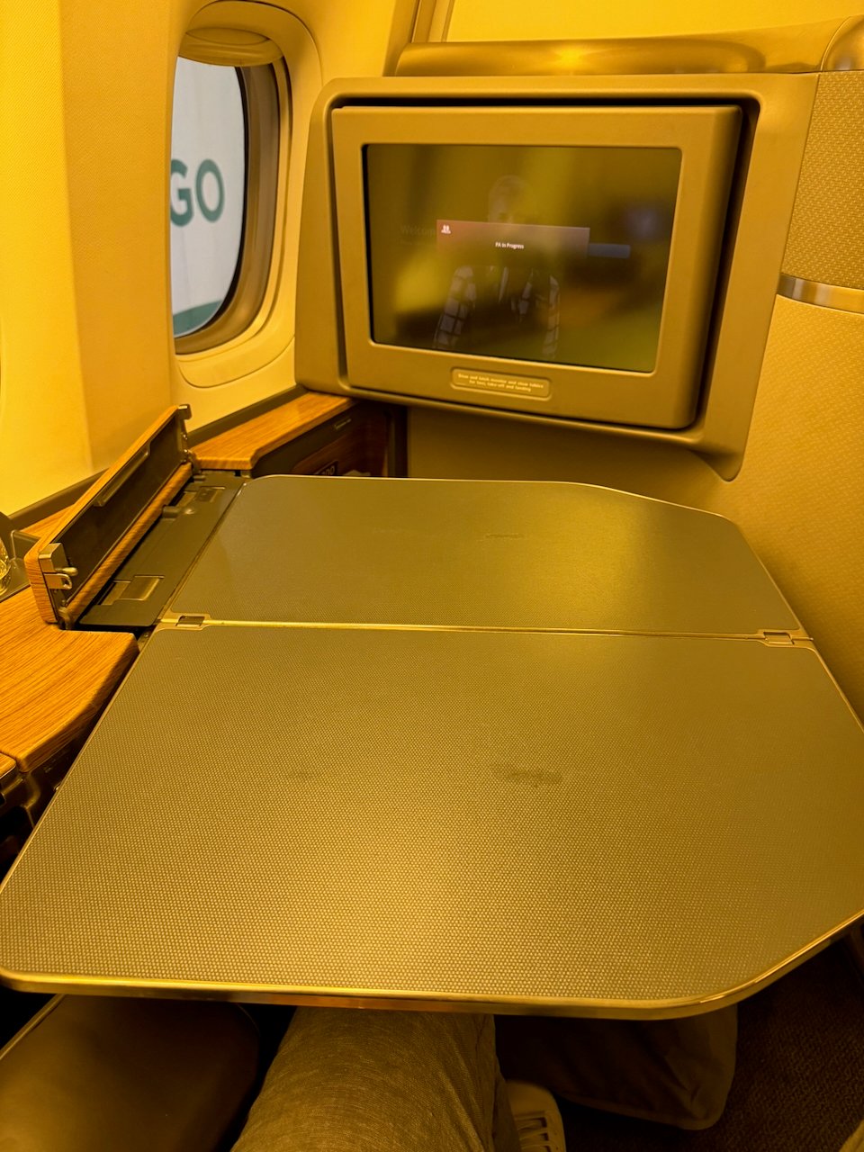 Tray table partially open at the American 777 Flagship First seat.