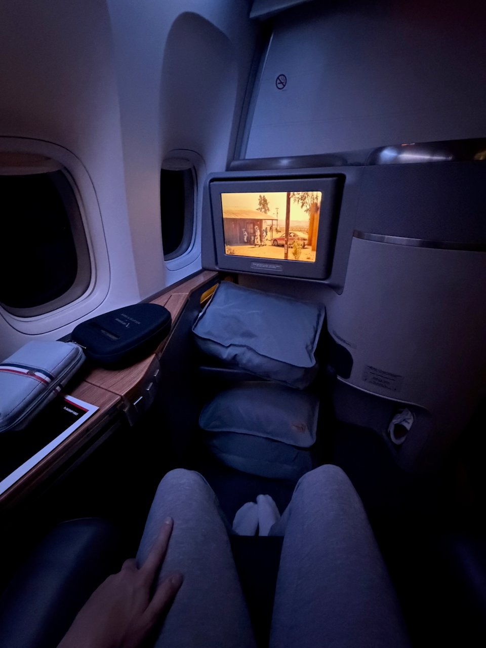 Darkened Flagship First cabin with seat and IFE after takeoff.