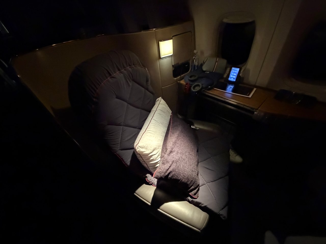 American Flagship First seat reclined into sleep mode with bedding.