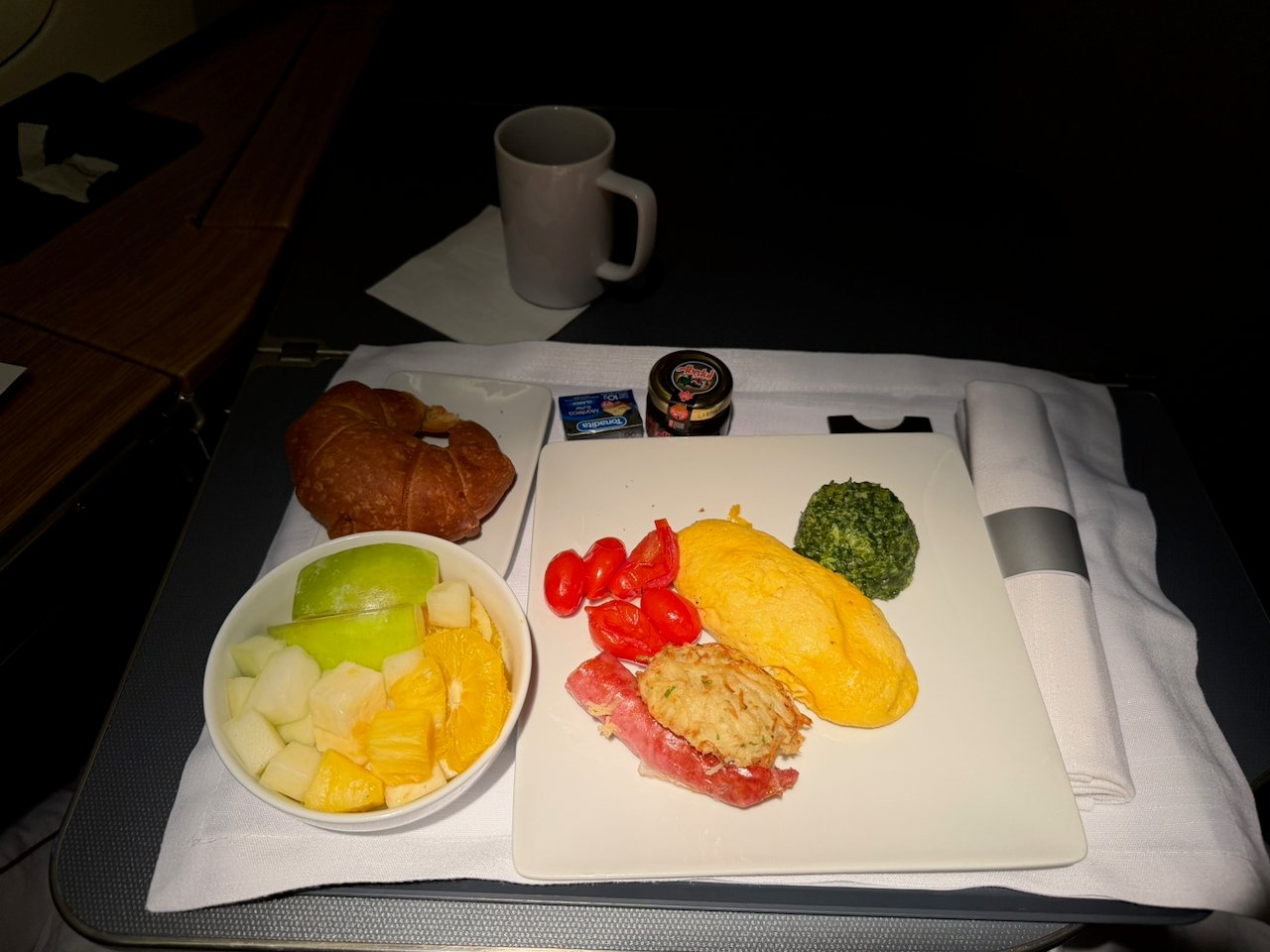 Breakfast tray with omelette, fruit, and croissant in Flagship First.
