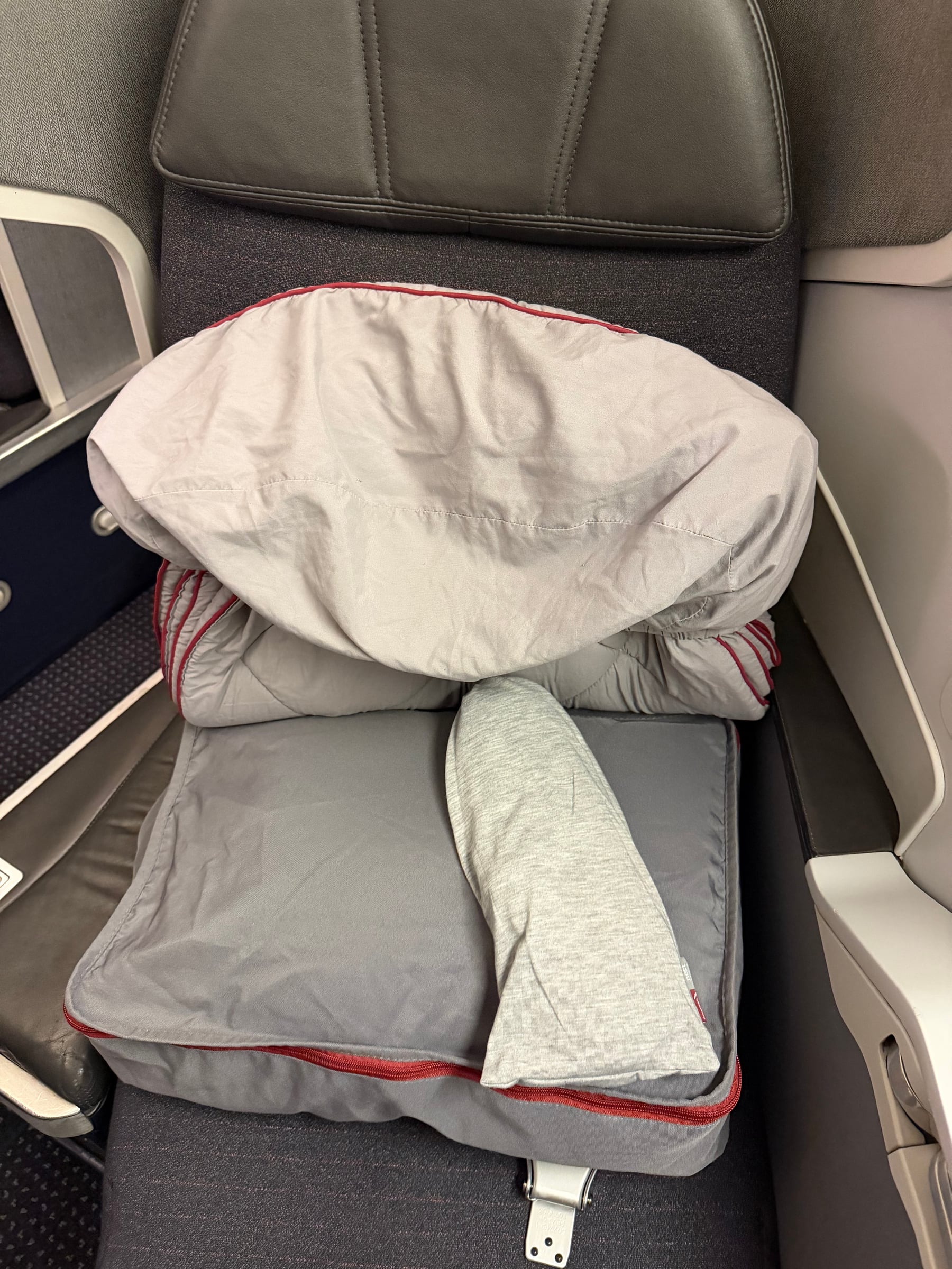 Pillow and blanket waiting at the American Airlines Flagship Business seat.