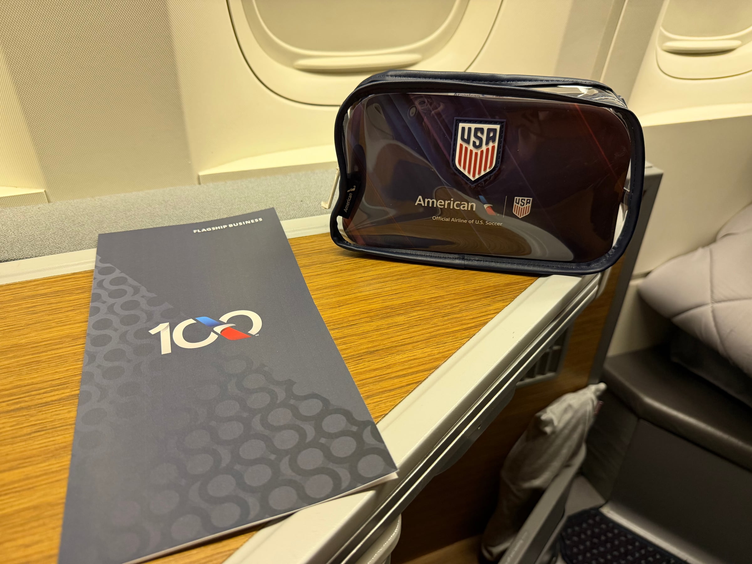 U.S. Soccer amenity kit and American Airlines centennial menu at the Business Class seat.