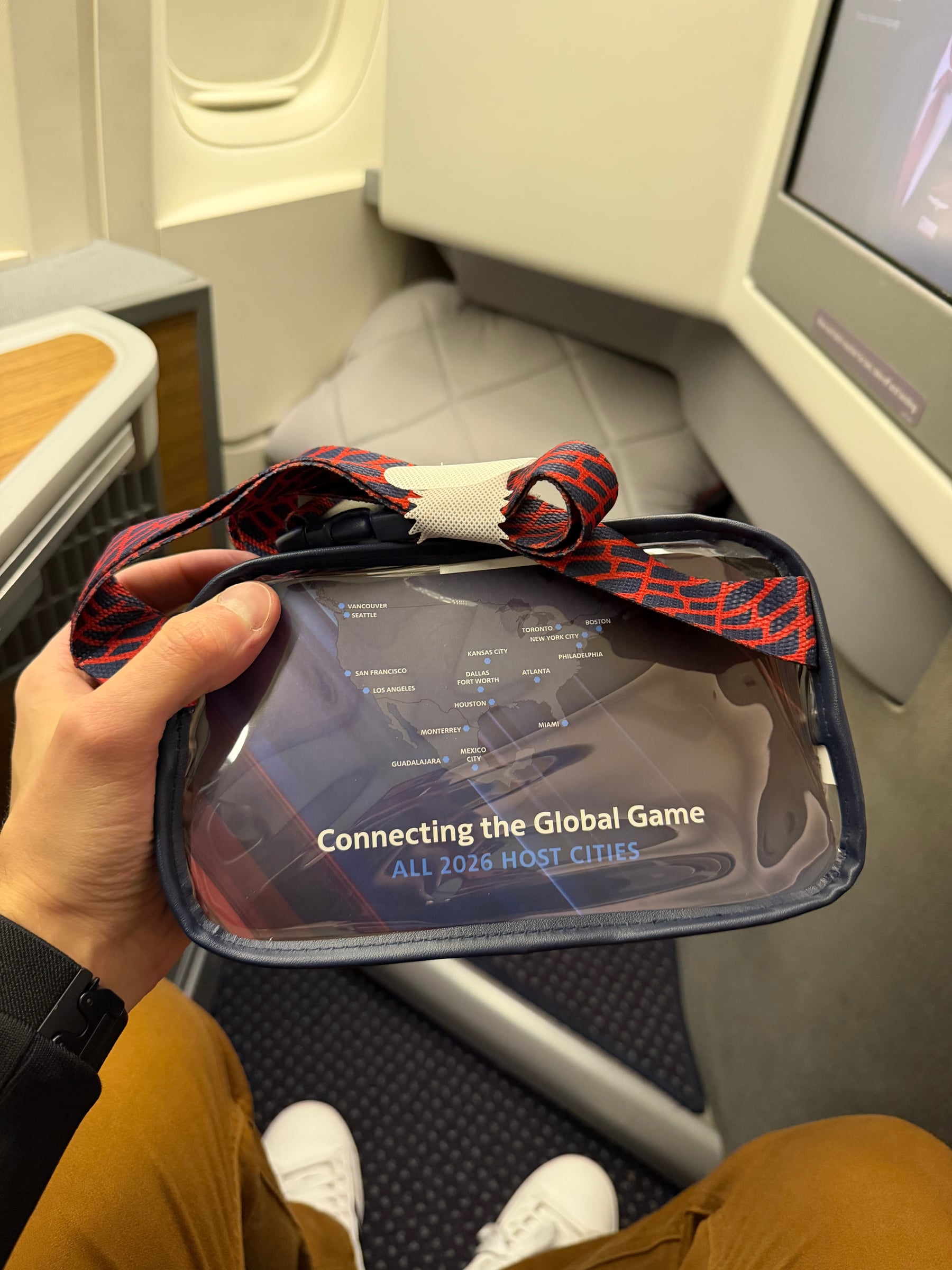 Back of the U.S. Soccer amenity kit showing its crossbody strap and Connecting the Global Game message.
