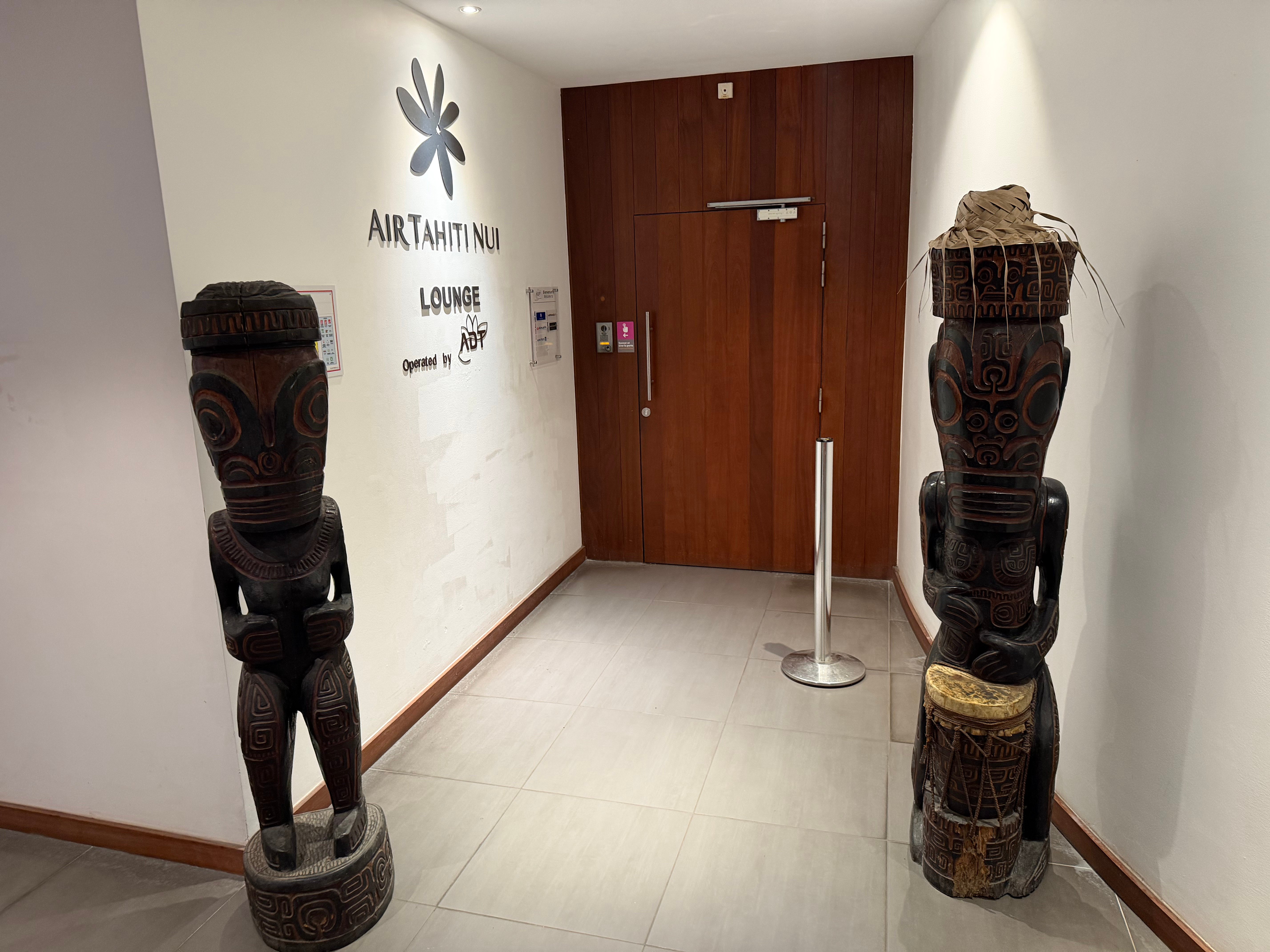 Carved figures beside the Air Tahiti Nui lounge entrance.