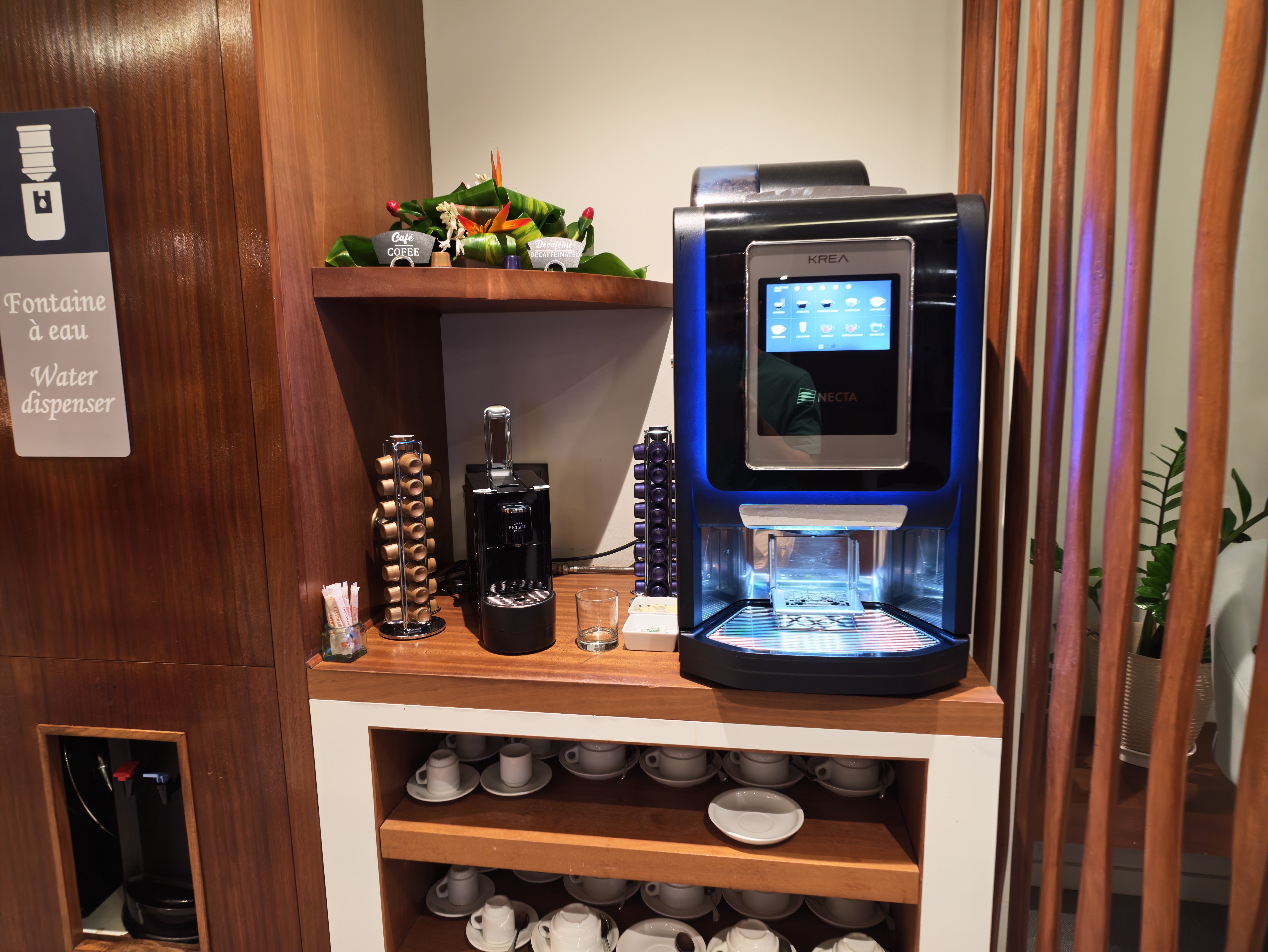 Coffee station beside a drinking water sign in the lounge.