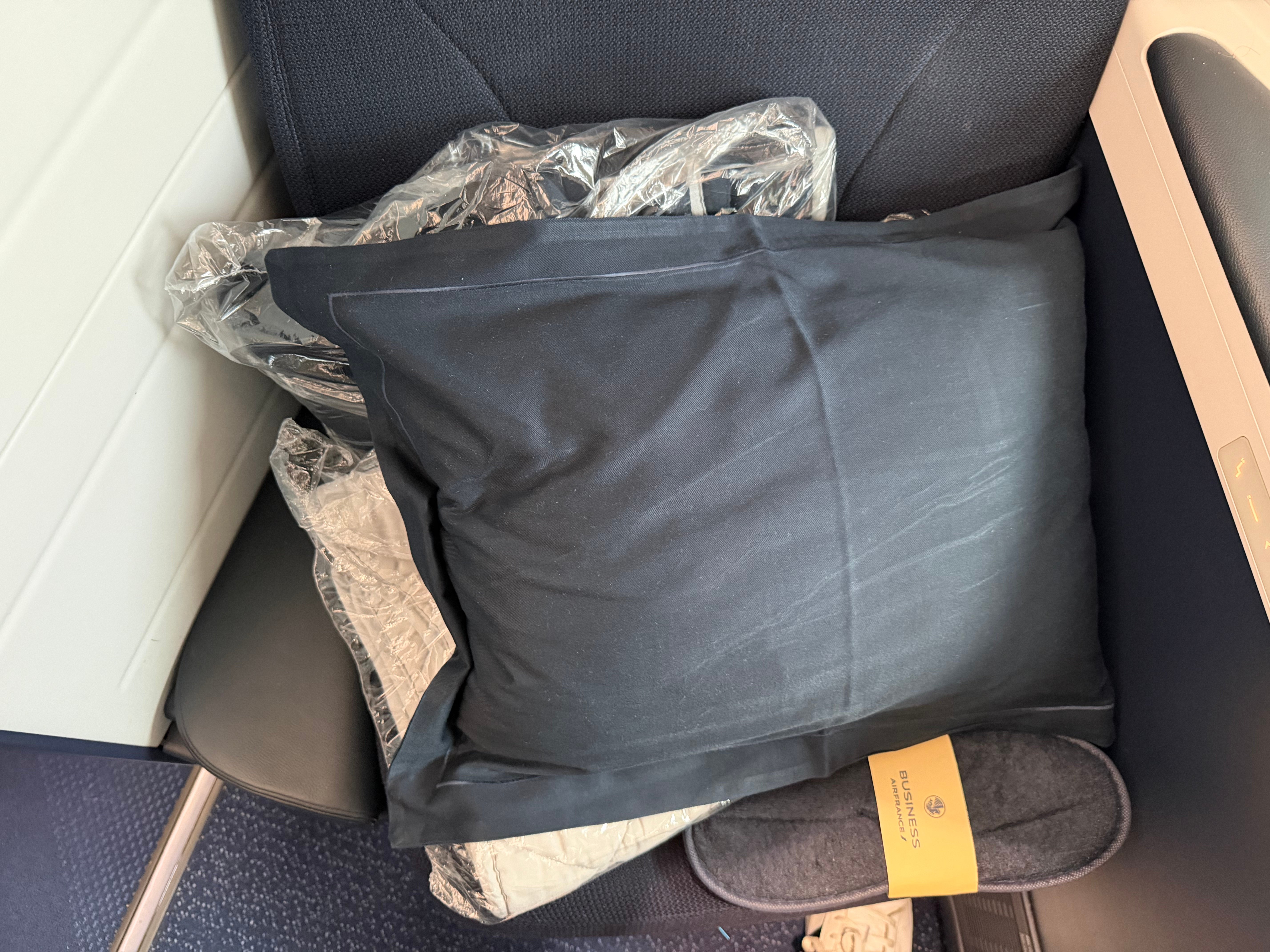 Pillow and slippers on the Business Class seat.