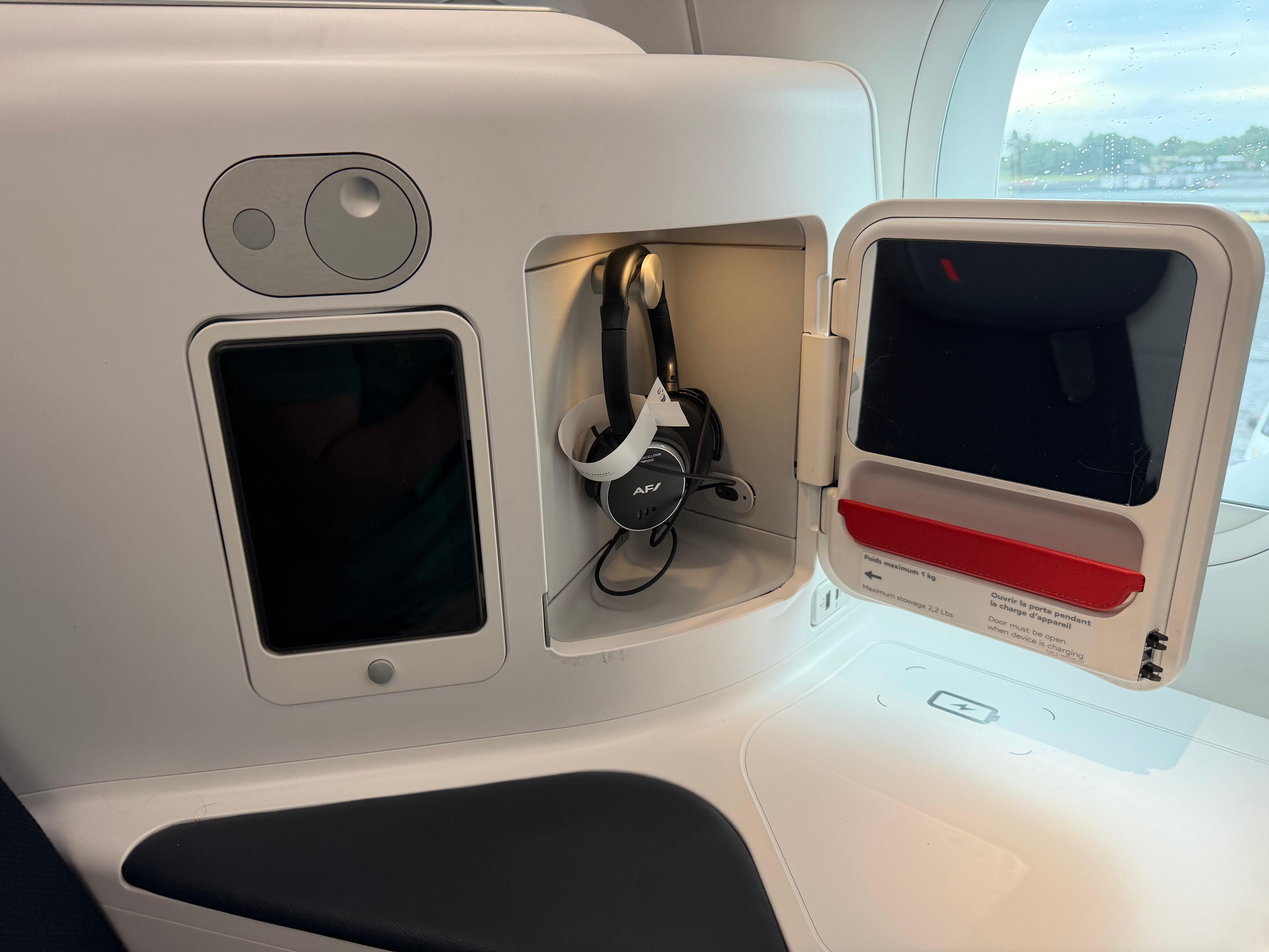 Open storage compartment with a mirror and headphones.