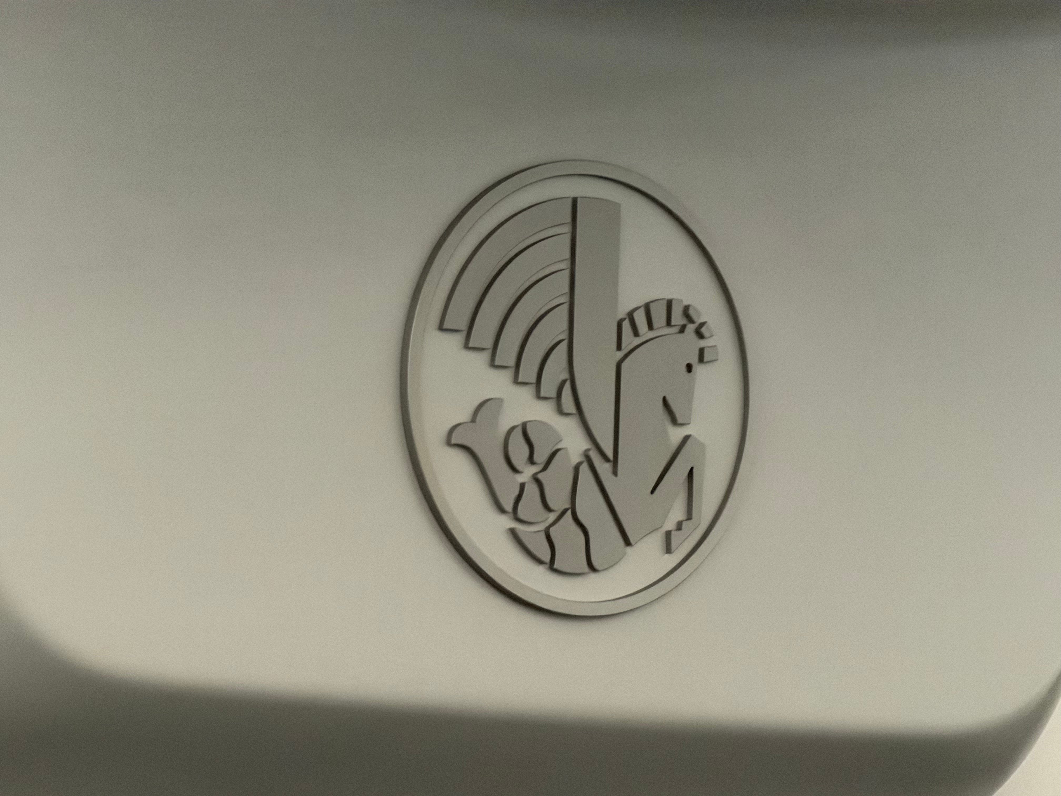Illuminated winged seahorse logo on the suite wall.