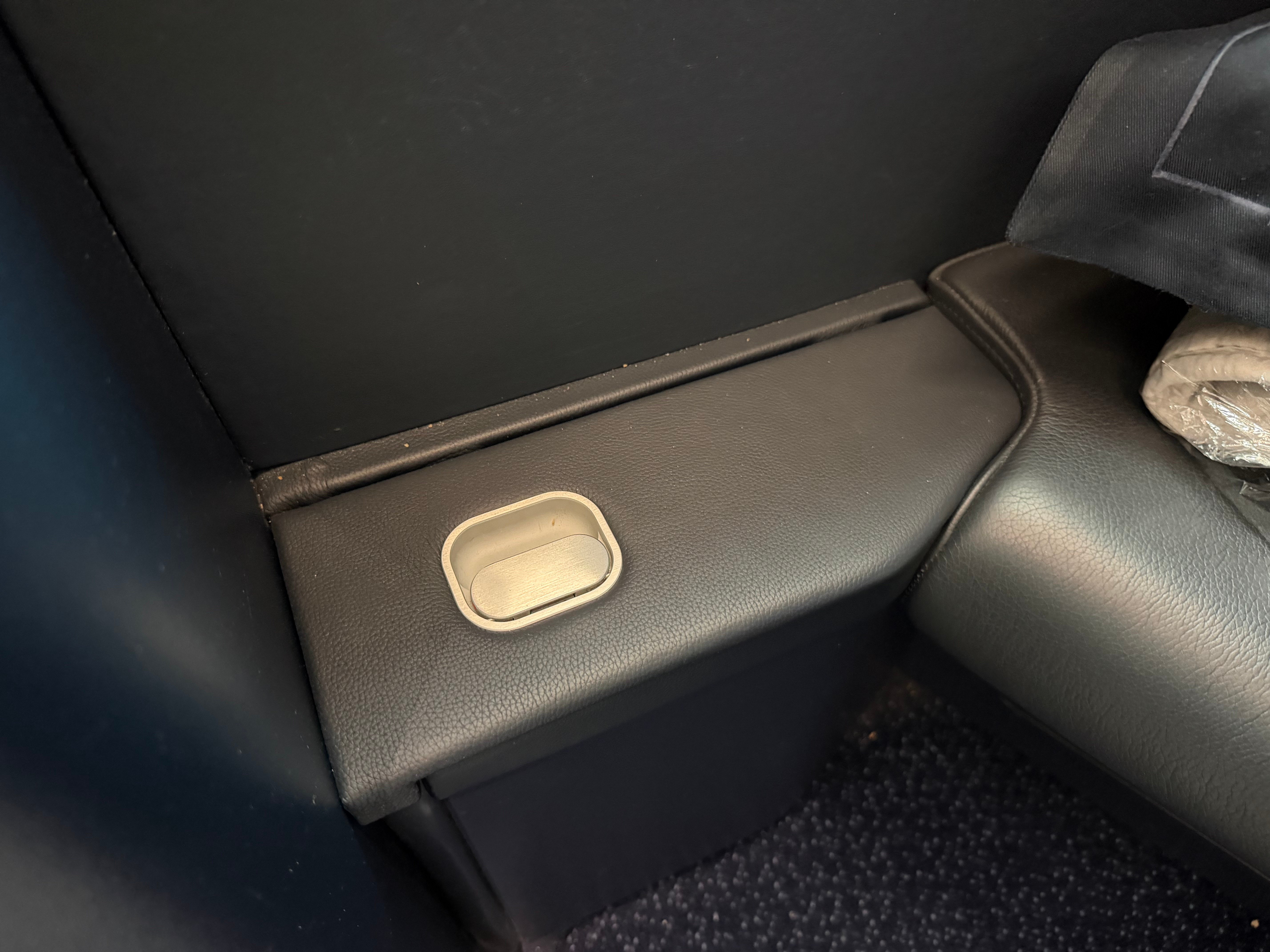 Armrest adjustment button at the Business Class seat.