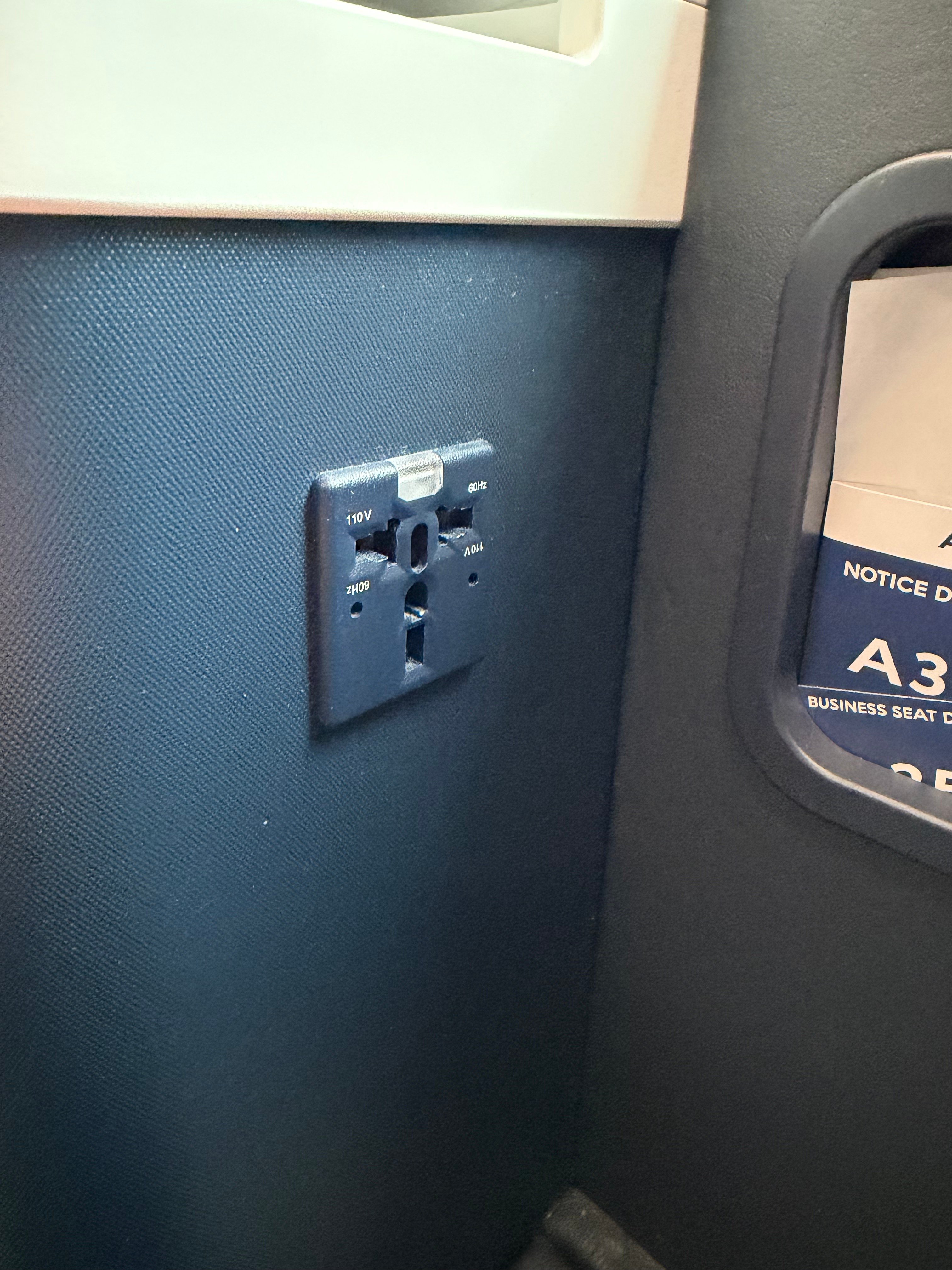 Universal power outlet at the Business Class seat.