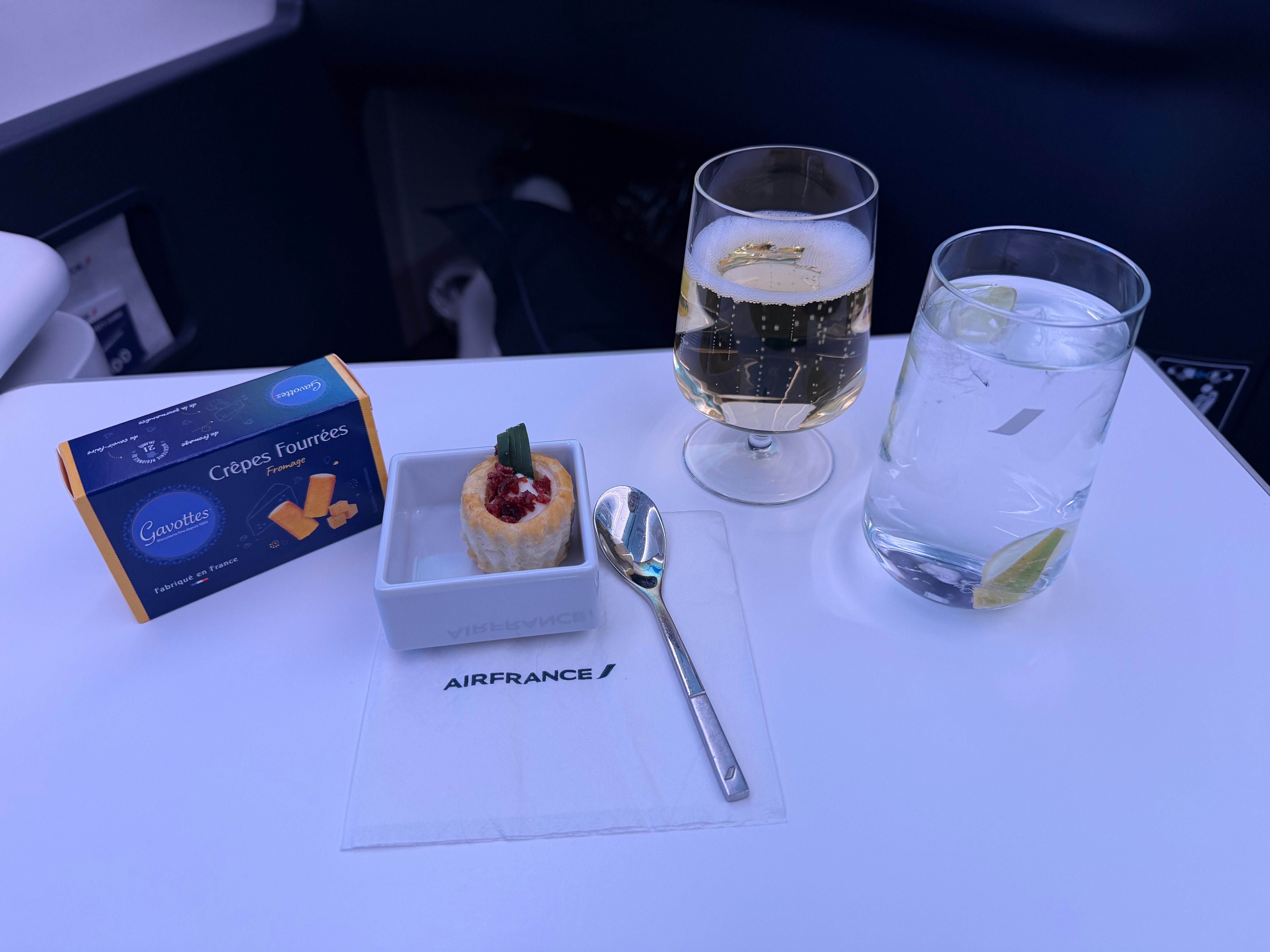 Champagne, water, biscuits, and a goat cheese and cranberry bite.