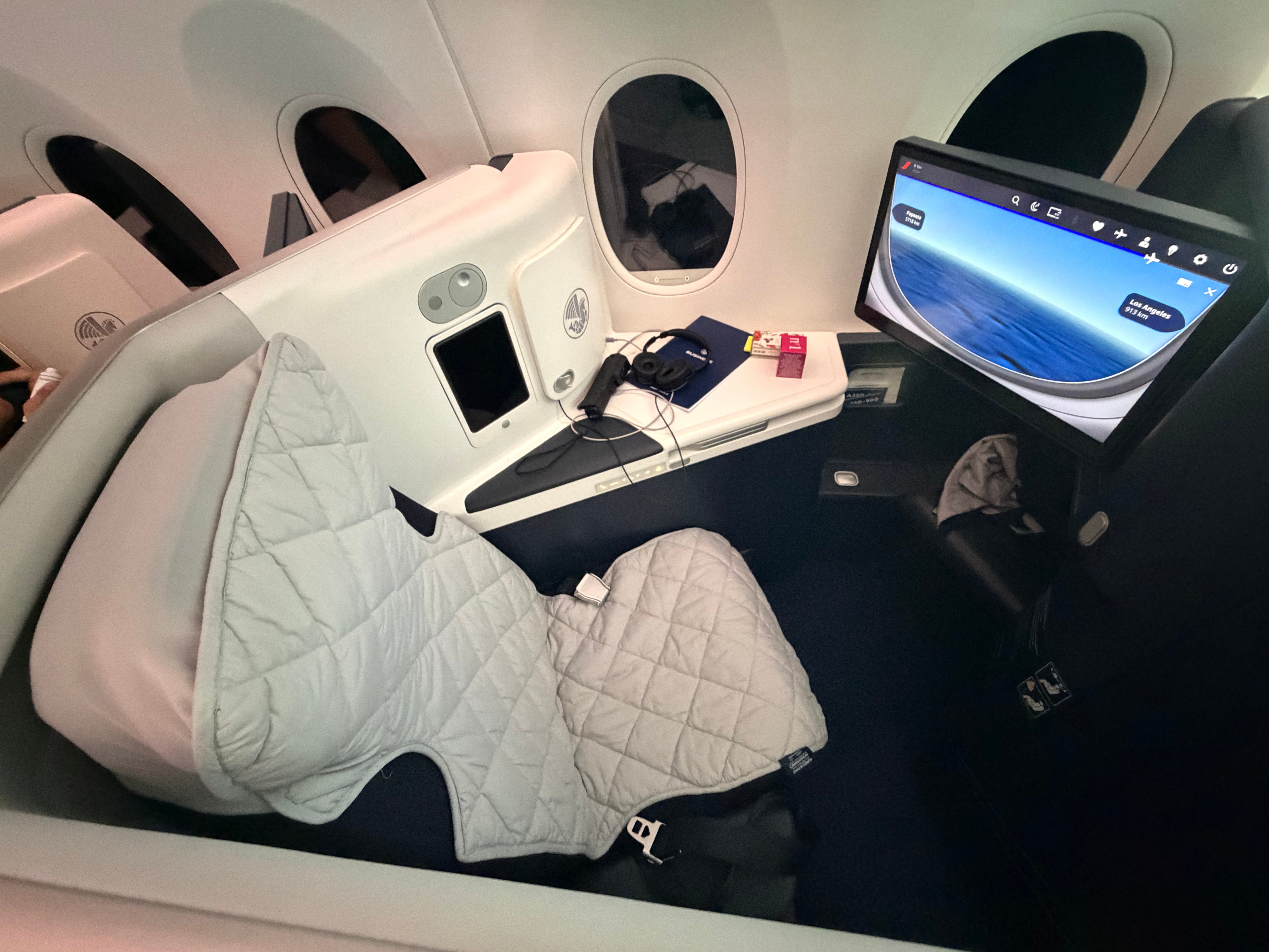Suite with bedding in place and the flight map on screen.