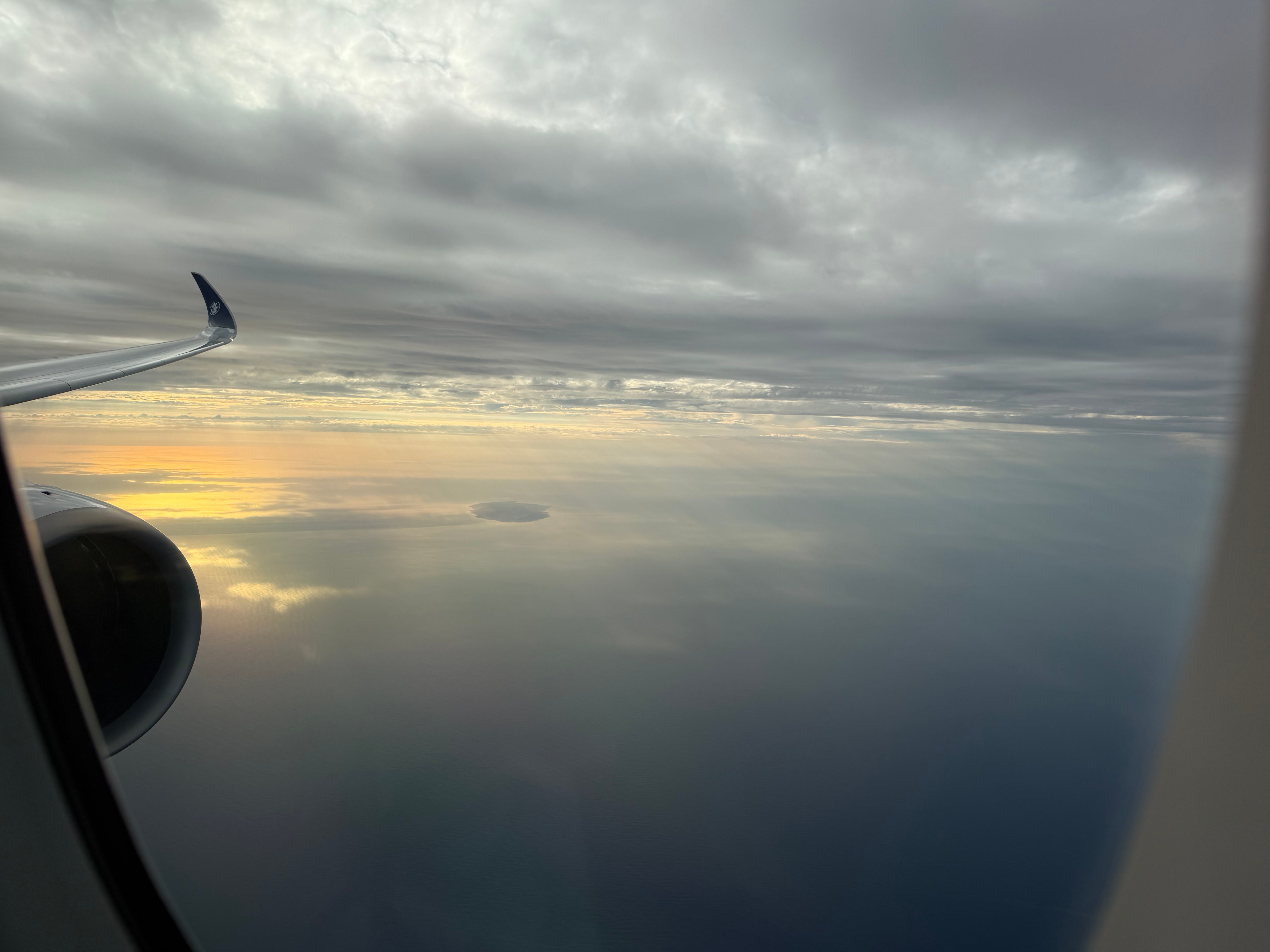 Golden evening light over the wing and ocean.