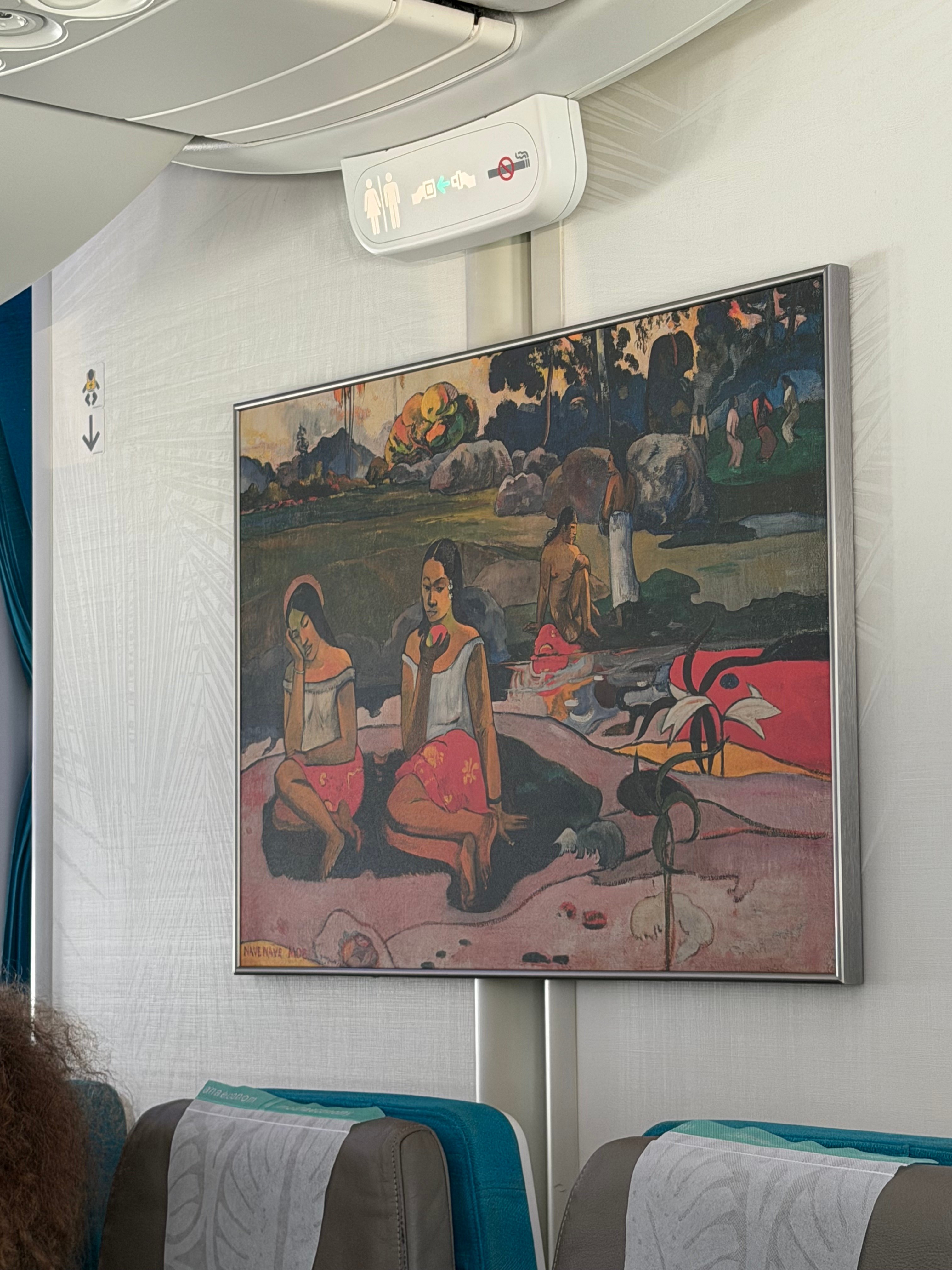 Polynesian artwork on a bulkhead in the Air Tahiti Nui Moana Economy cabin.