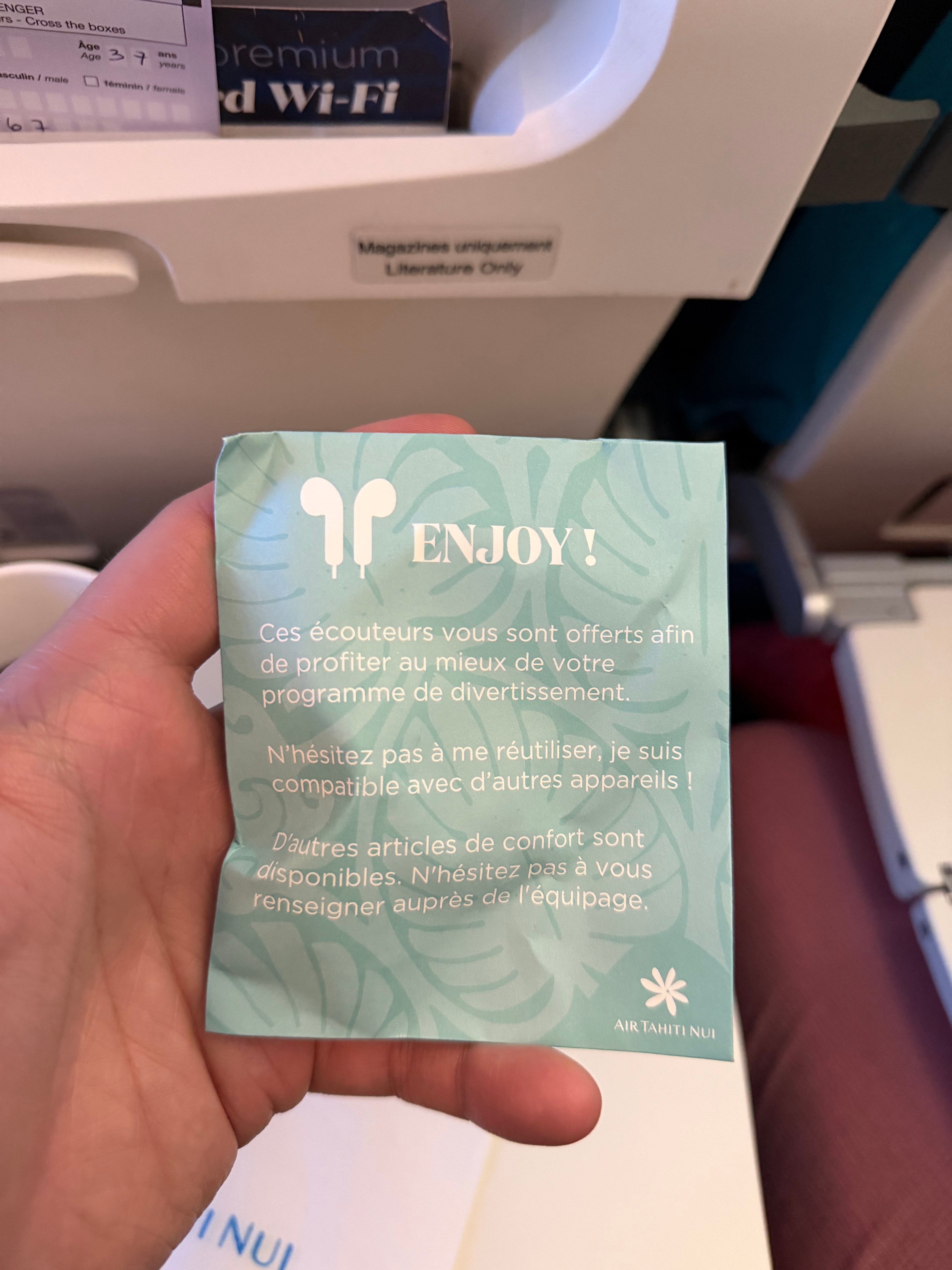 Front of the packaged earphones provided in Air Tahiti Nui Economy Class.