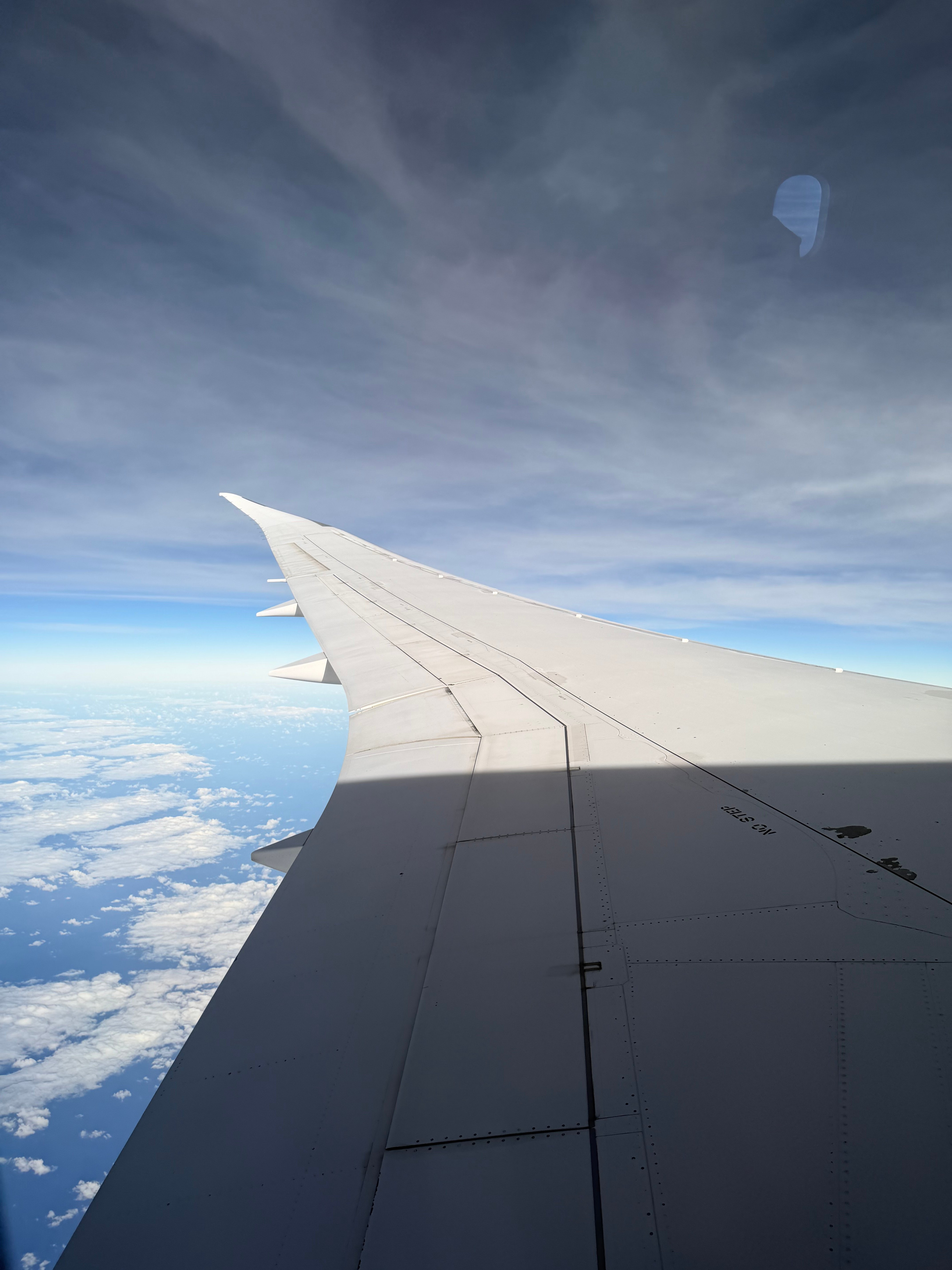 Air Tahiti Nui Boeing 787-9 wing above the clouds over the Pacific.