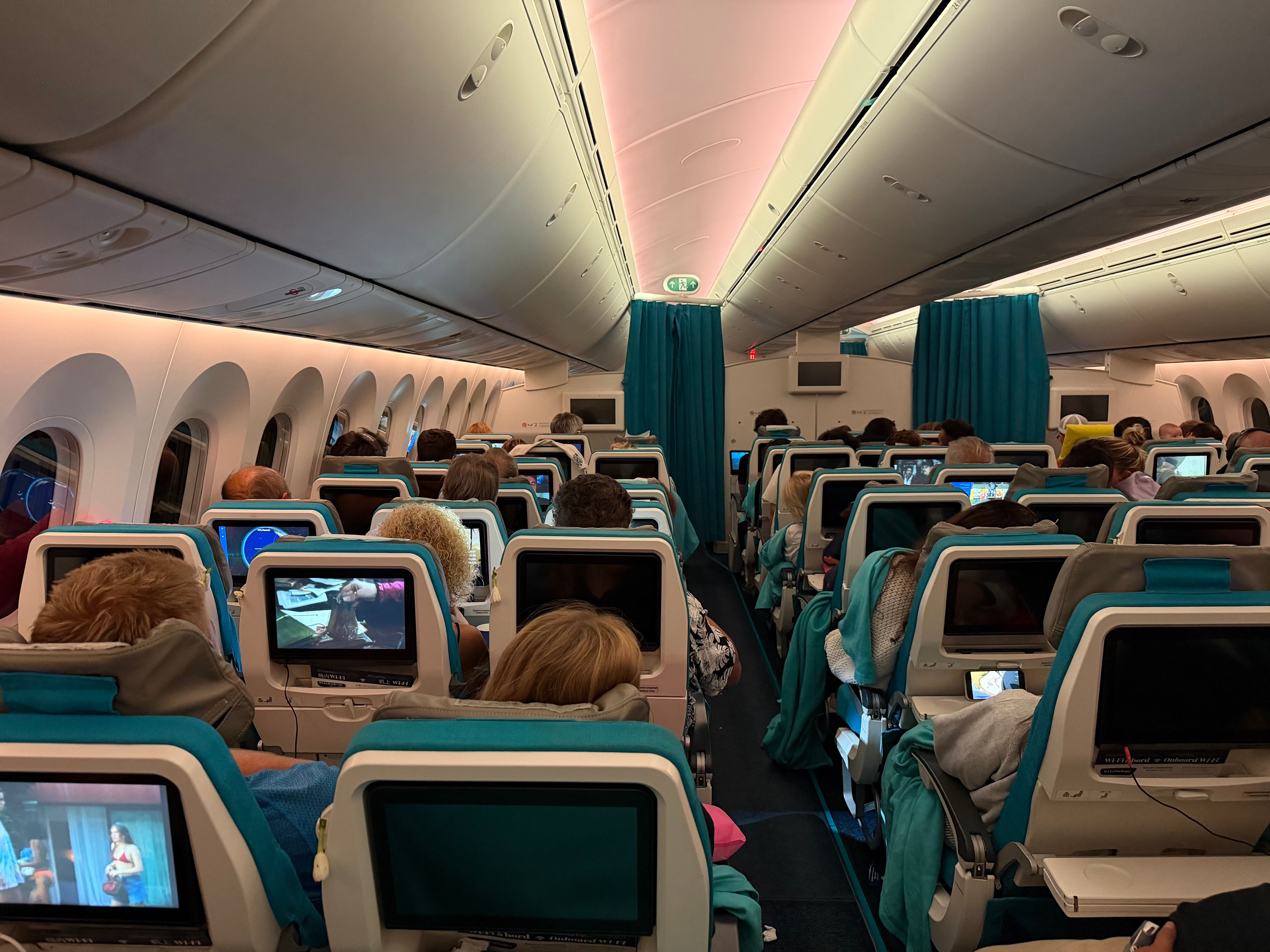 Air Tahiti Nui Moana Economy cabin with the lights on during flight.