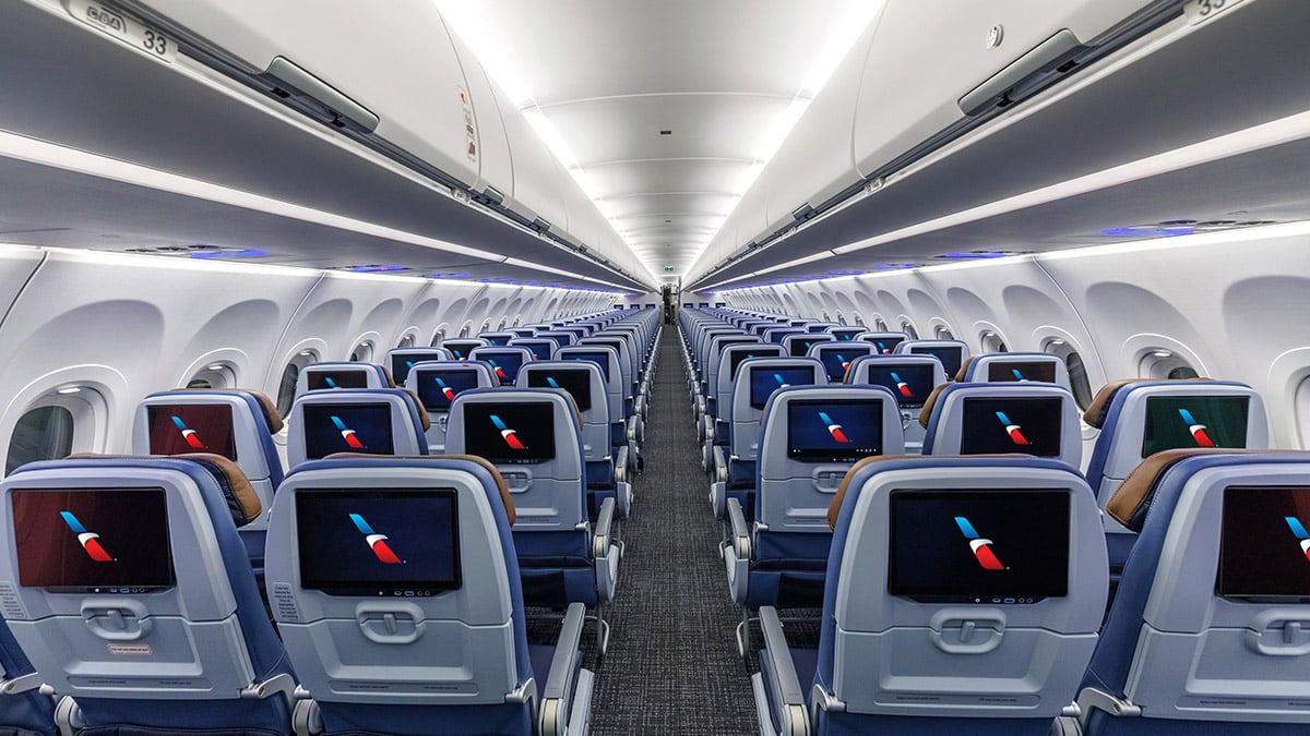 American Airlines cabin with individual seatback entertainment screens throughout Economy Class.