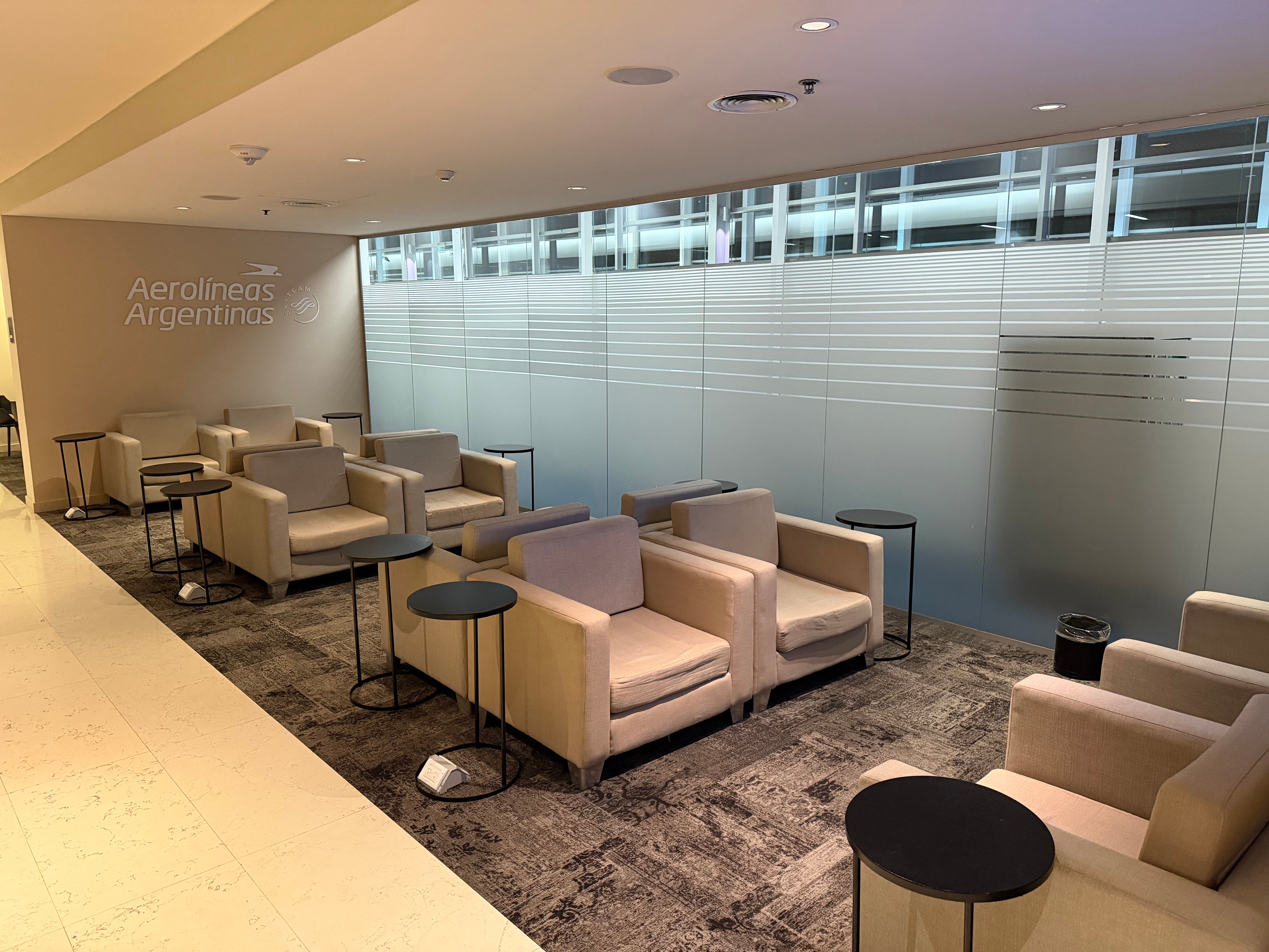Seating beside a glass wall inside the Aerolíneas Argentinas Condor Lounge.