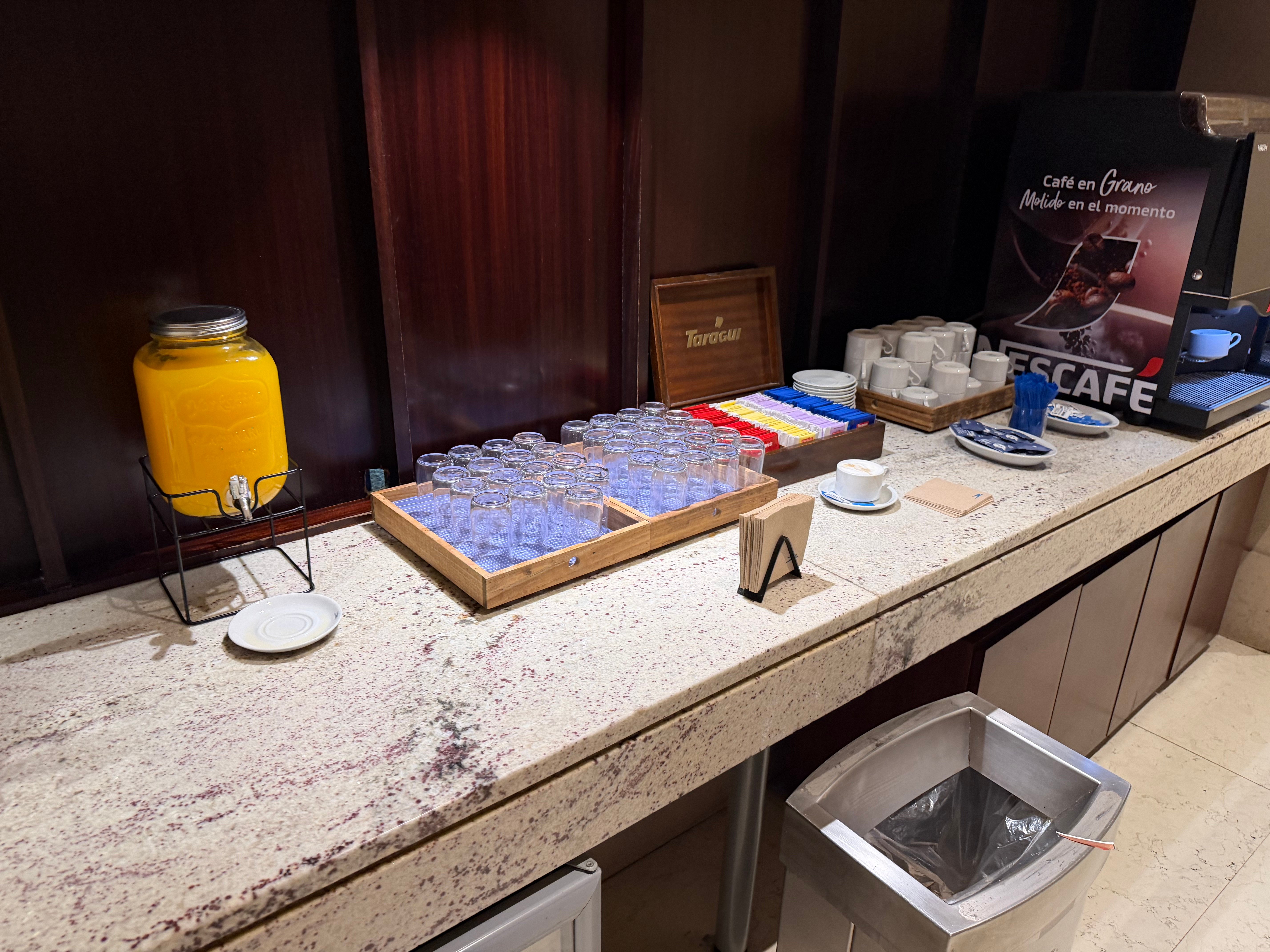 Juice, water, and snack station inside the Aerolíneas Argentinas Condor Lounge.