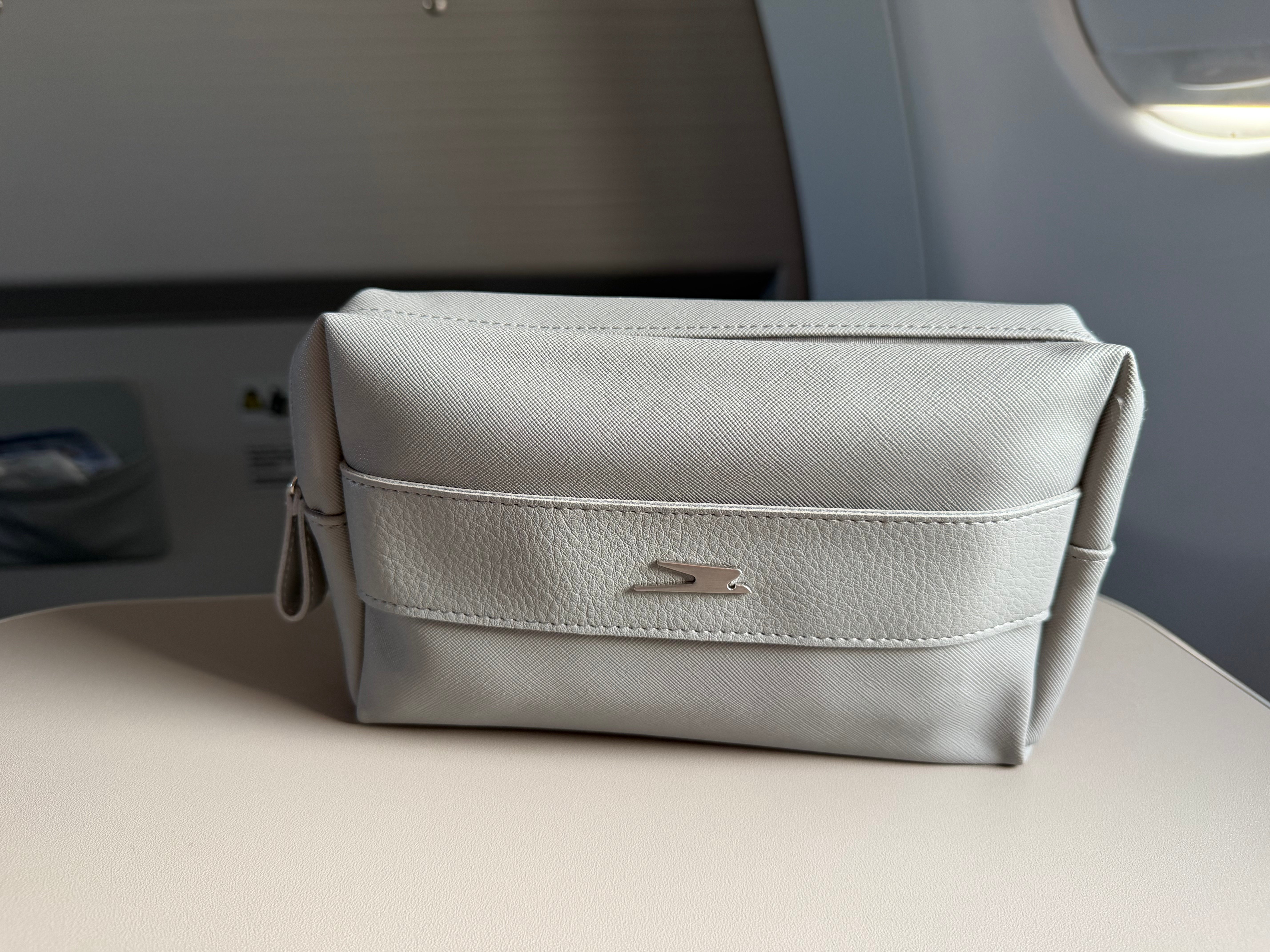 Aerolíneas Argentinas Business Class amenity kit bag on the tray table.