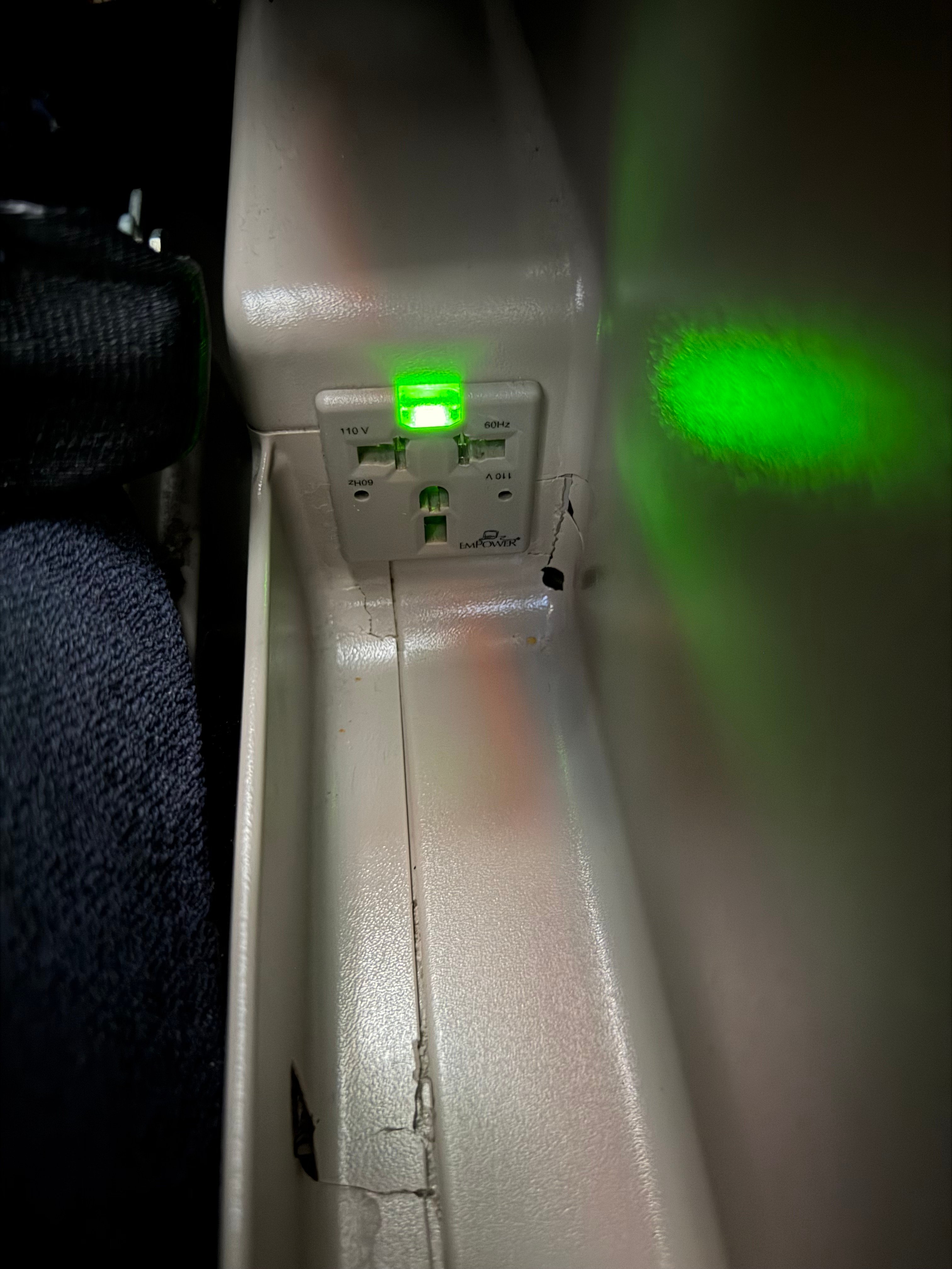 Power outlet beside an Aerolíneas Argentinas A330 Business Class seat.