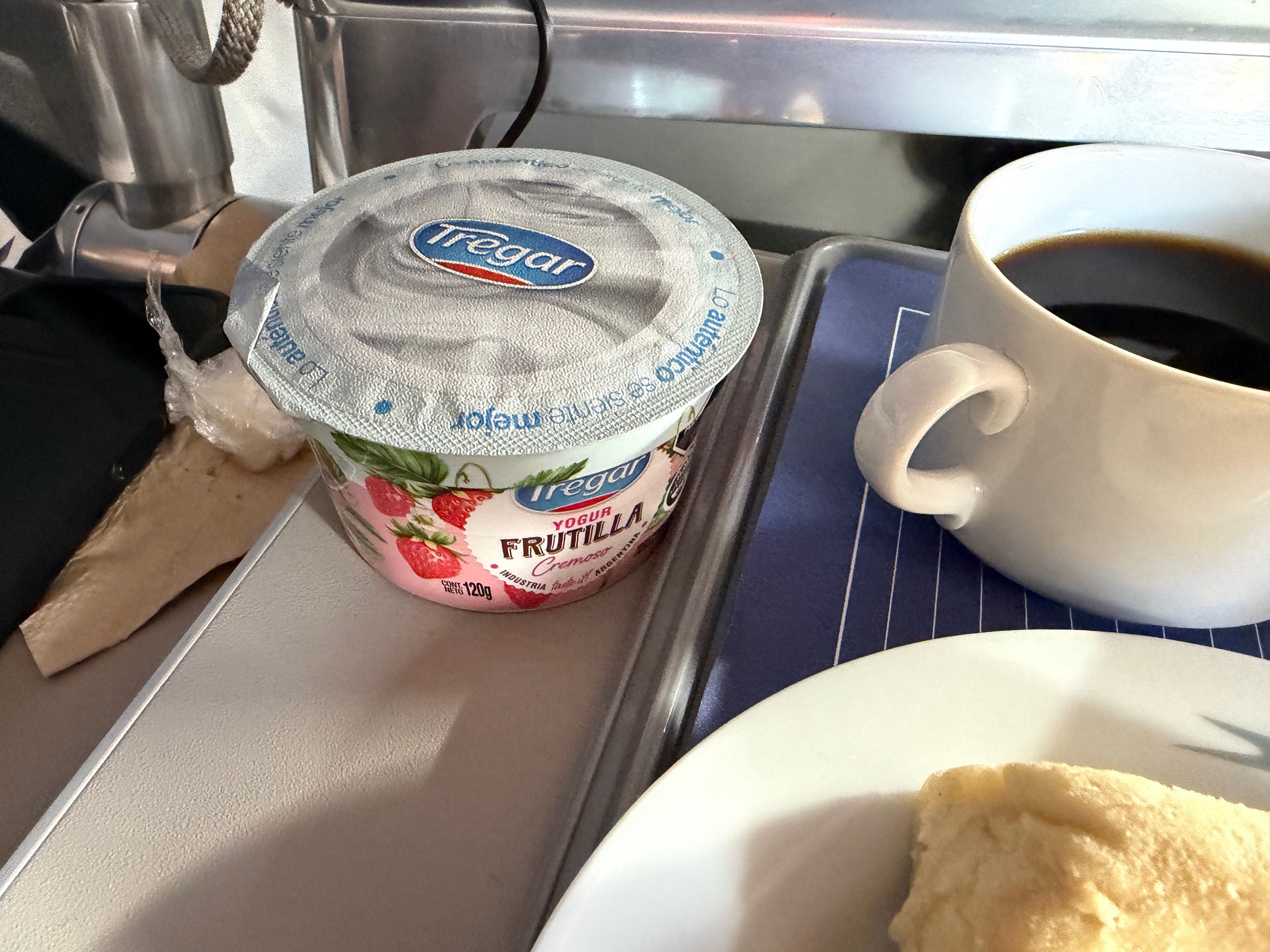 Yogurt, coffee, and bread served for breakfast in Aerolíneas Argentinas Business Class.
