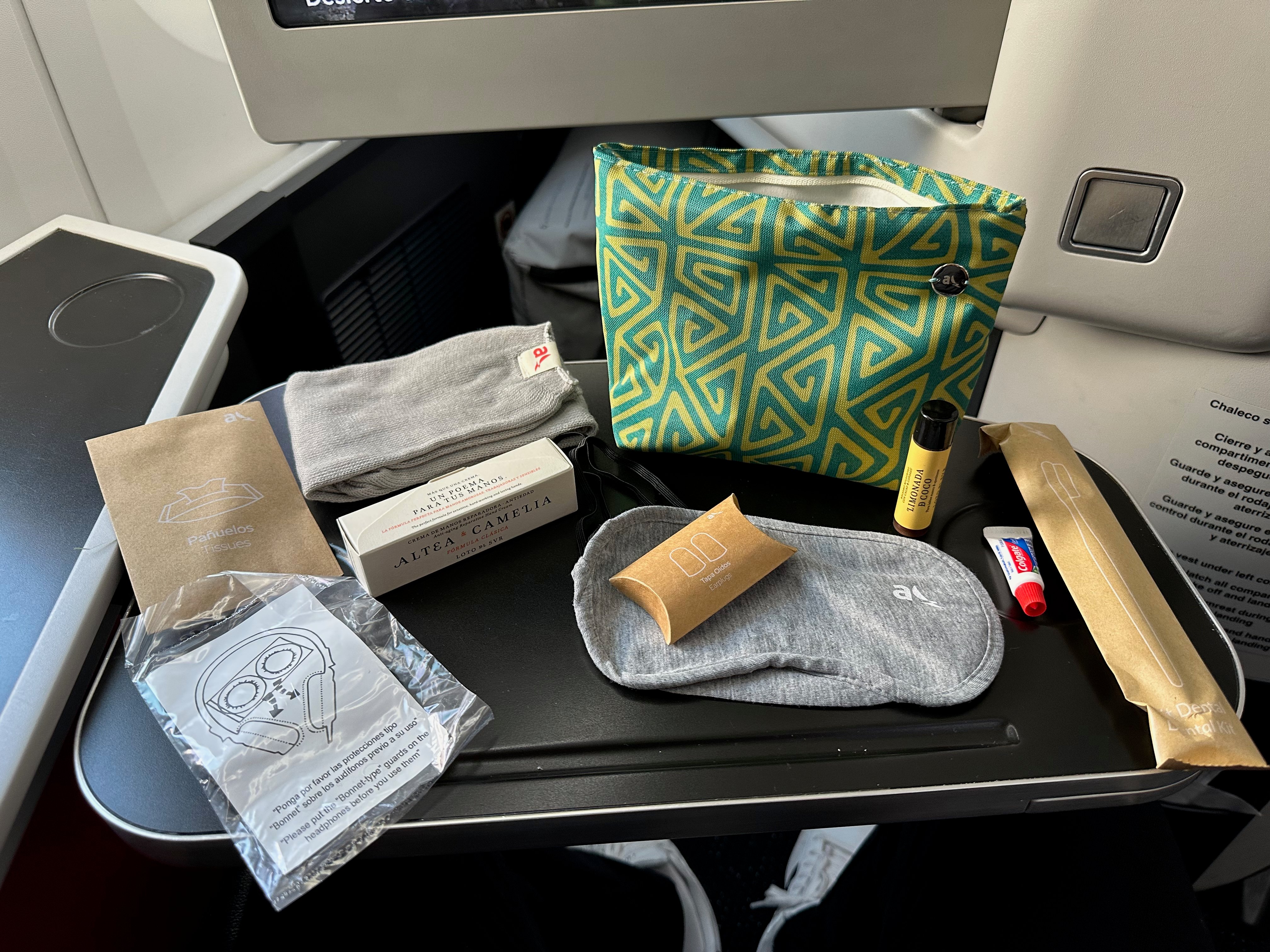 Patterned amenity kit with socks, eye mask, earplugs, and toiletries.