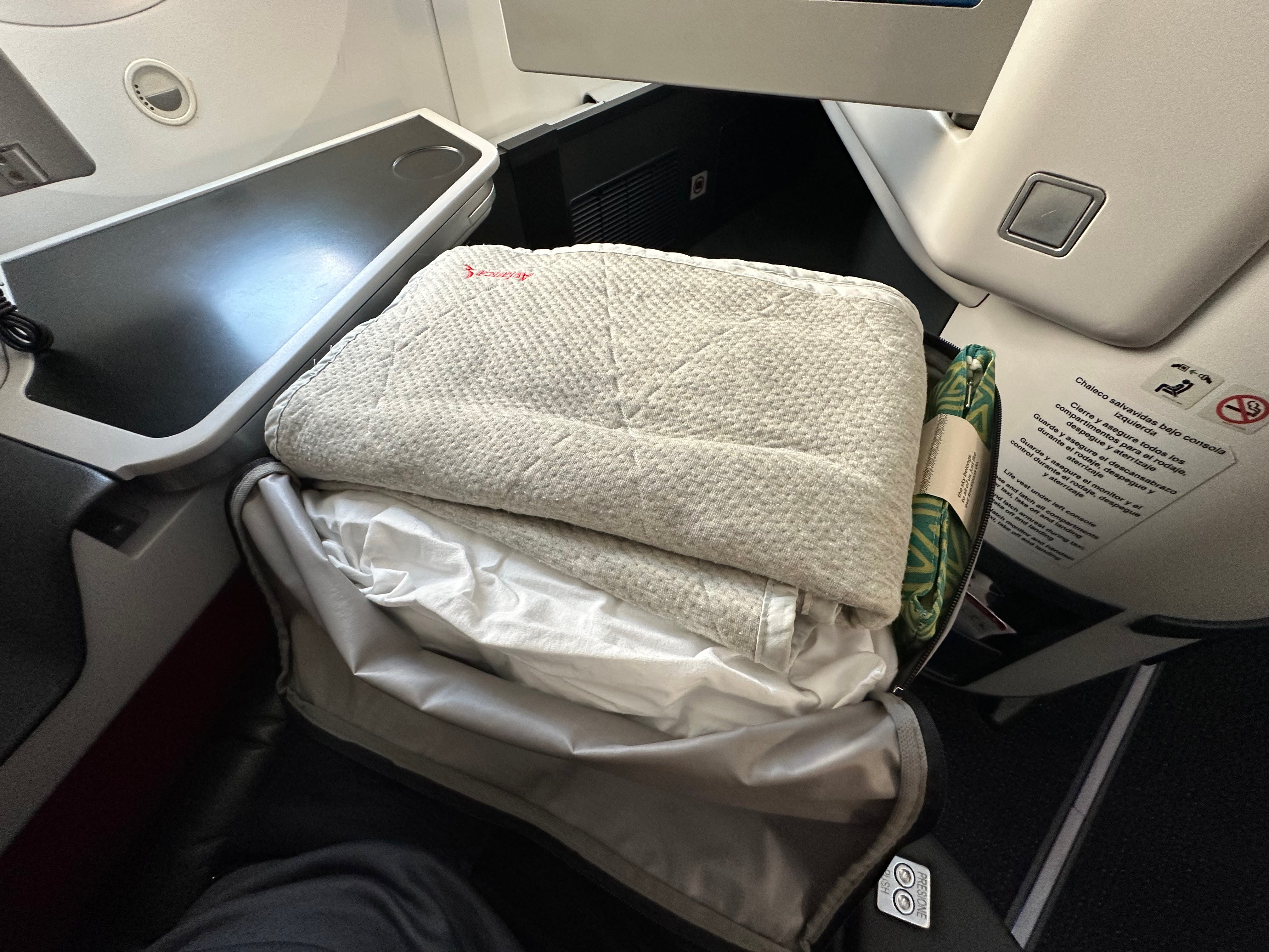 Pillow and blanket unpacked at the Business Class seat.