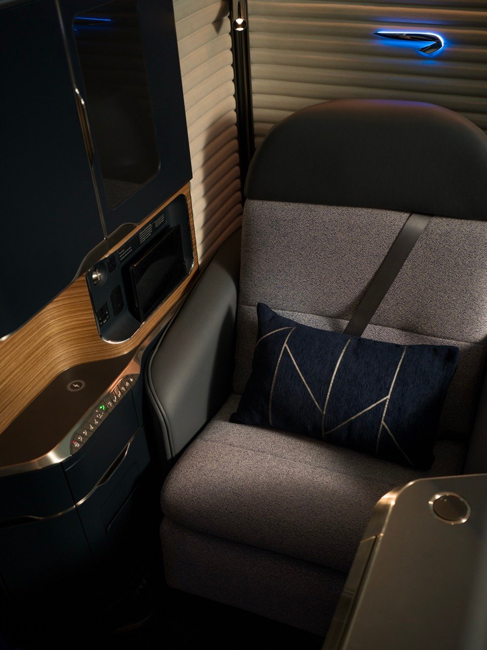 British Airways First publicity photograph showing a suite with a blanket and navy cushion.