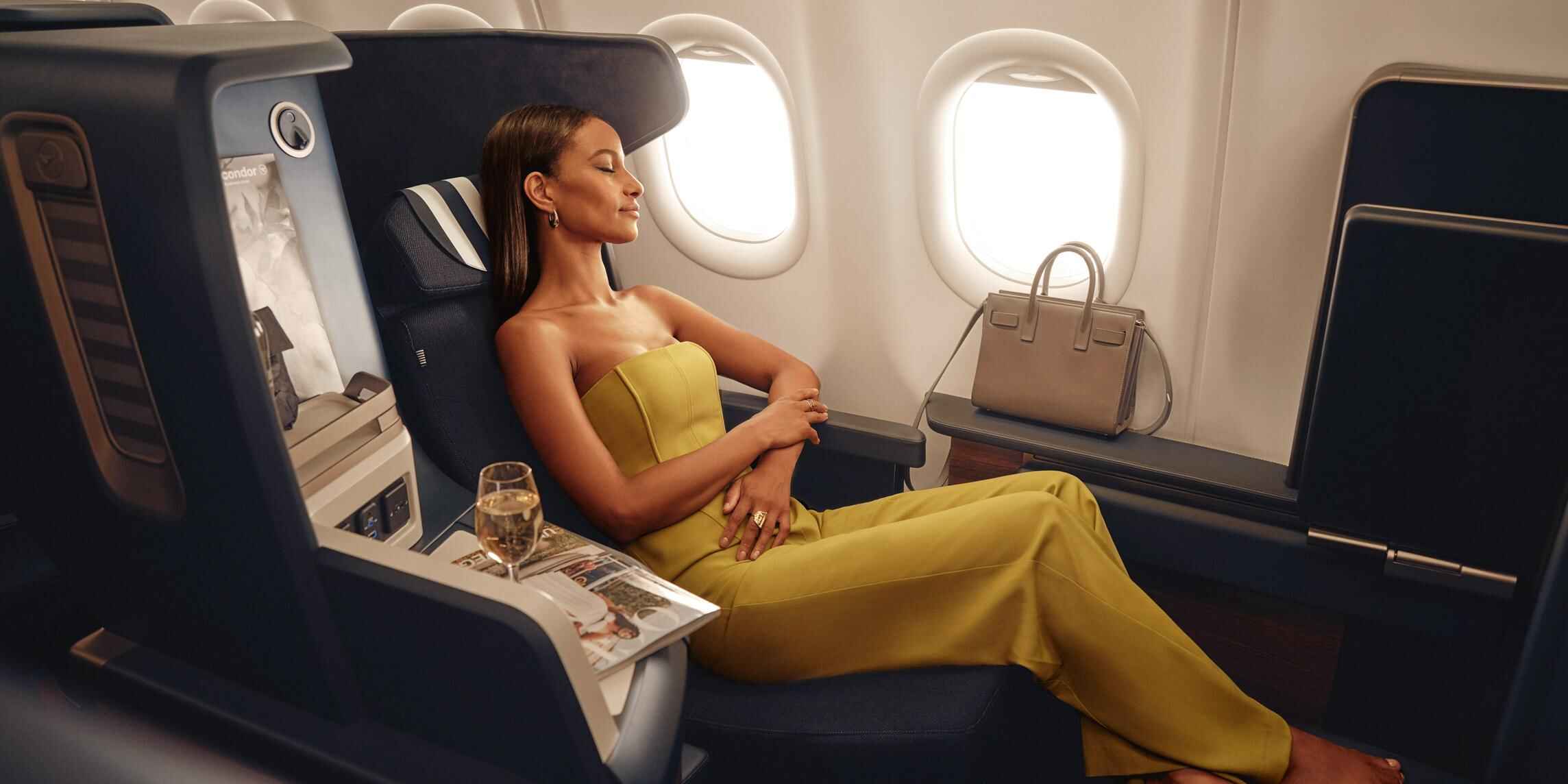 Passenger reclining in a window seat in Condor A330neo Business Class.