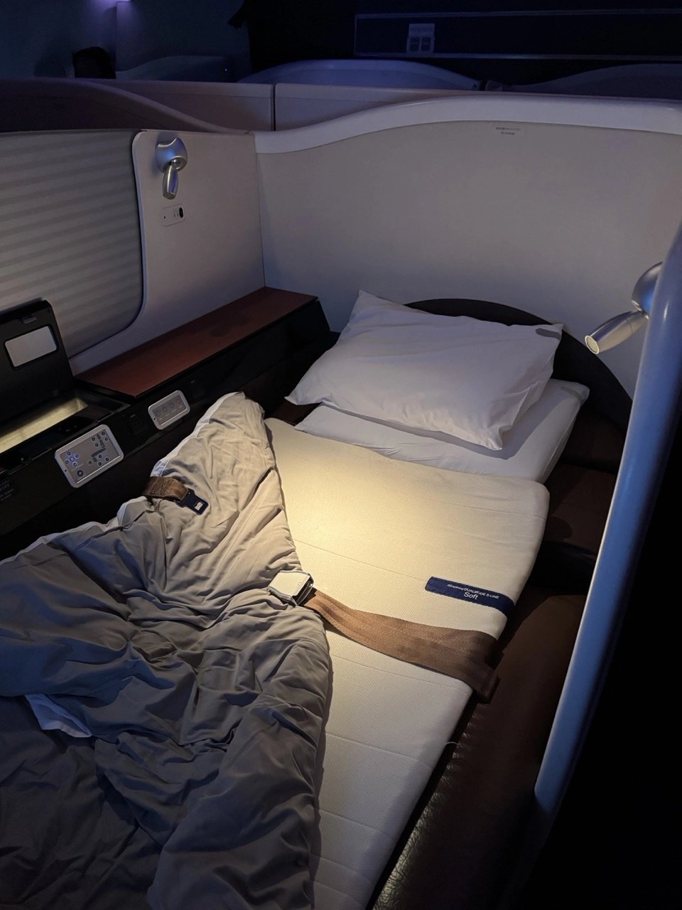 The fully flat bed in JAL First Class with soft mattress pad