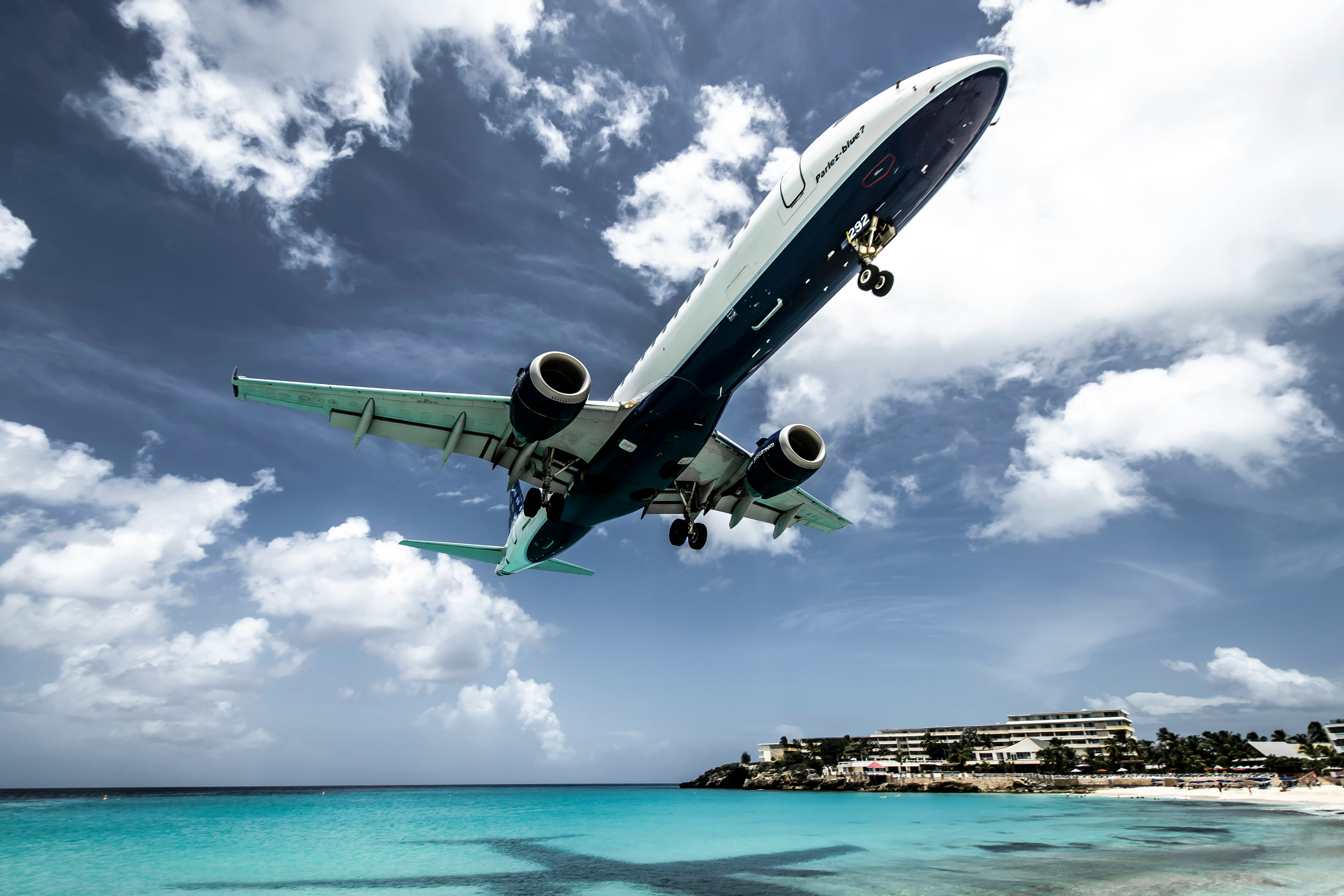 The tail of a JetBlue airplane against a blue sky.