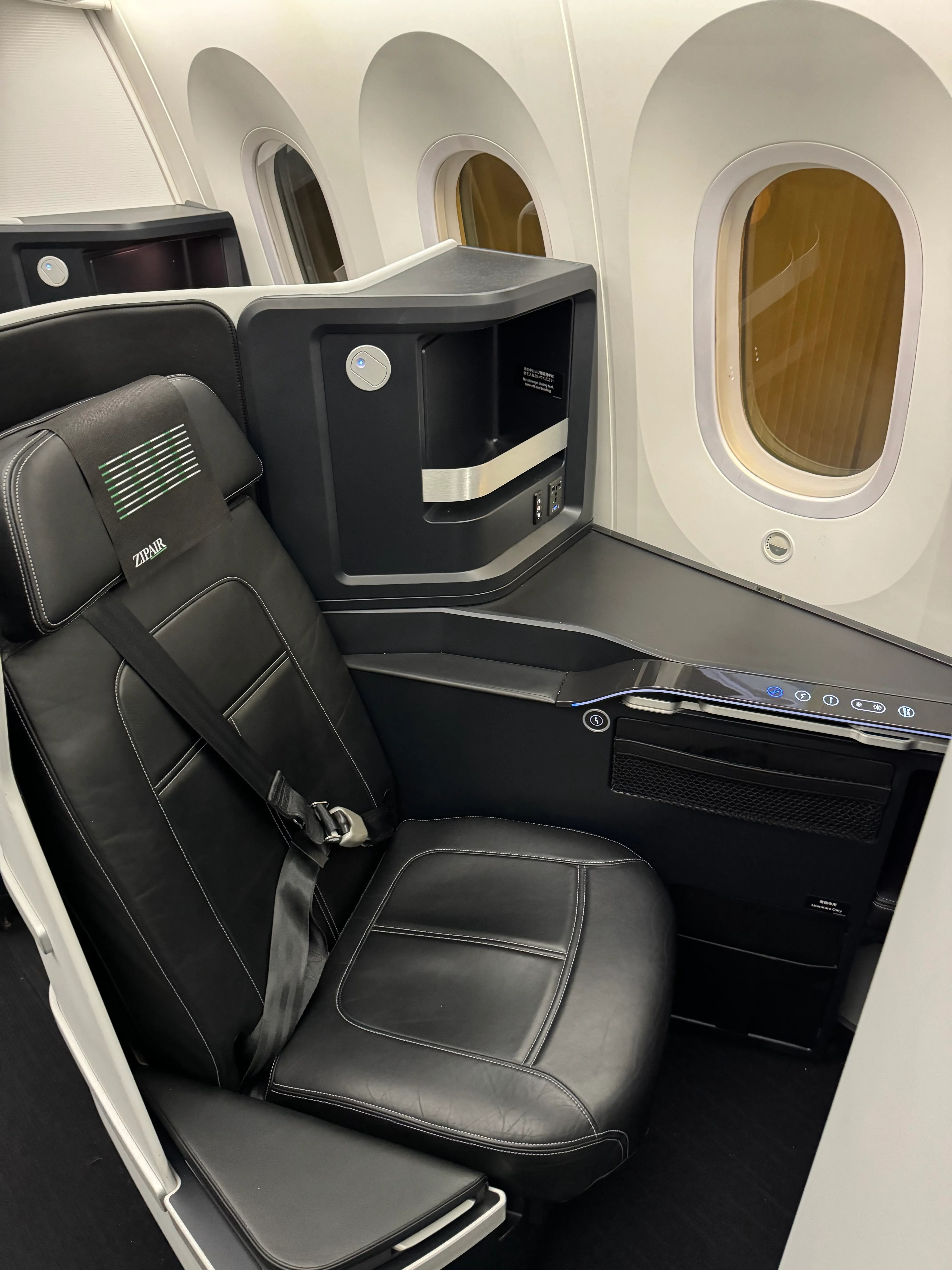 Wide view of the sleek black and white ZIPAIR cabin.